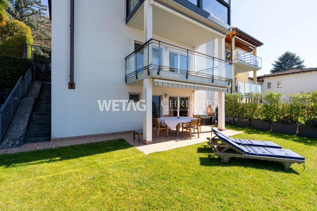 Gartenansicht einer modernen Wohnimmobilie mit Balkon und Terrasse