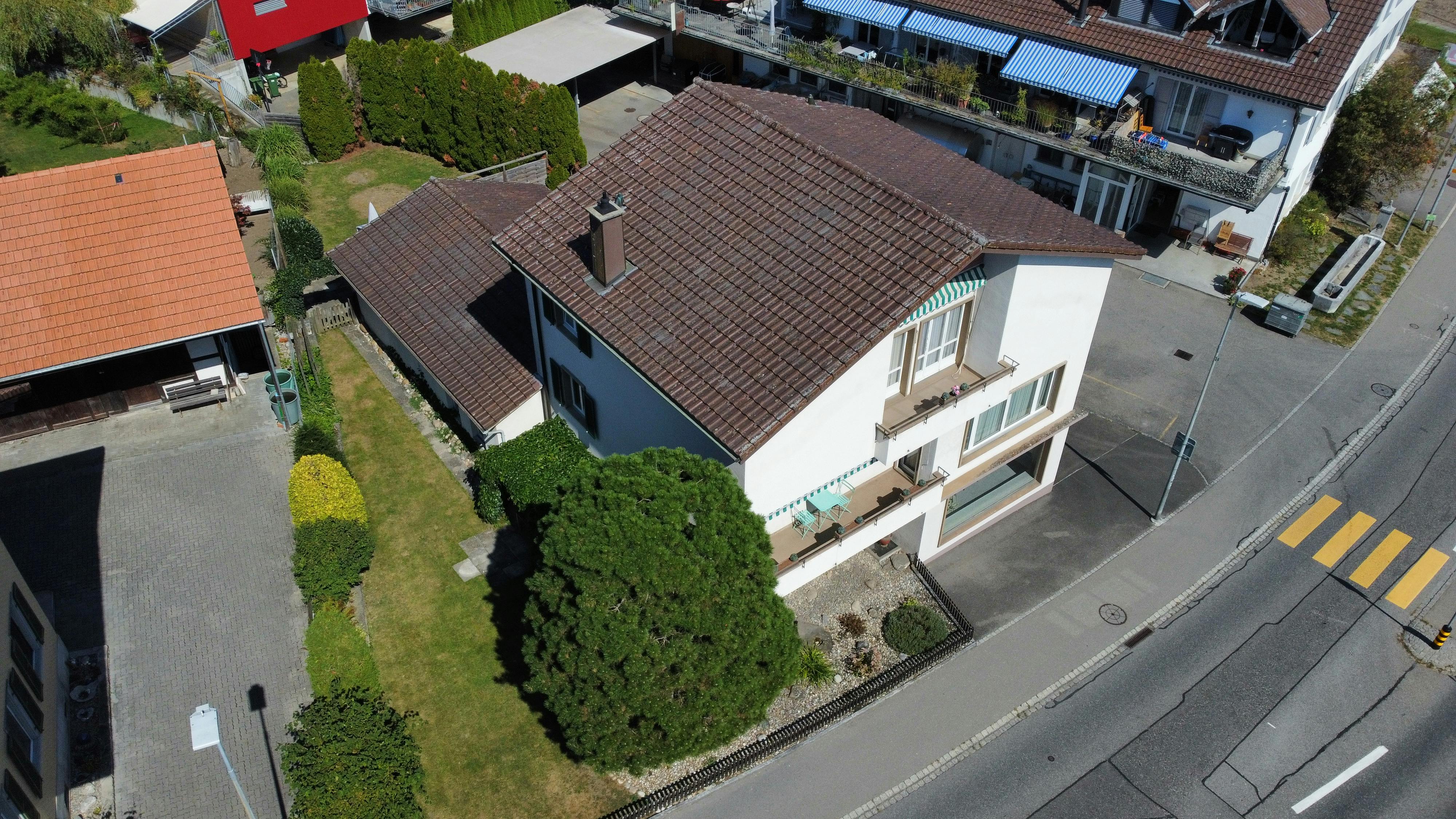 Luftaufnahme eines Wohnhauses mit Garten und Straßenfront