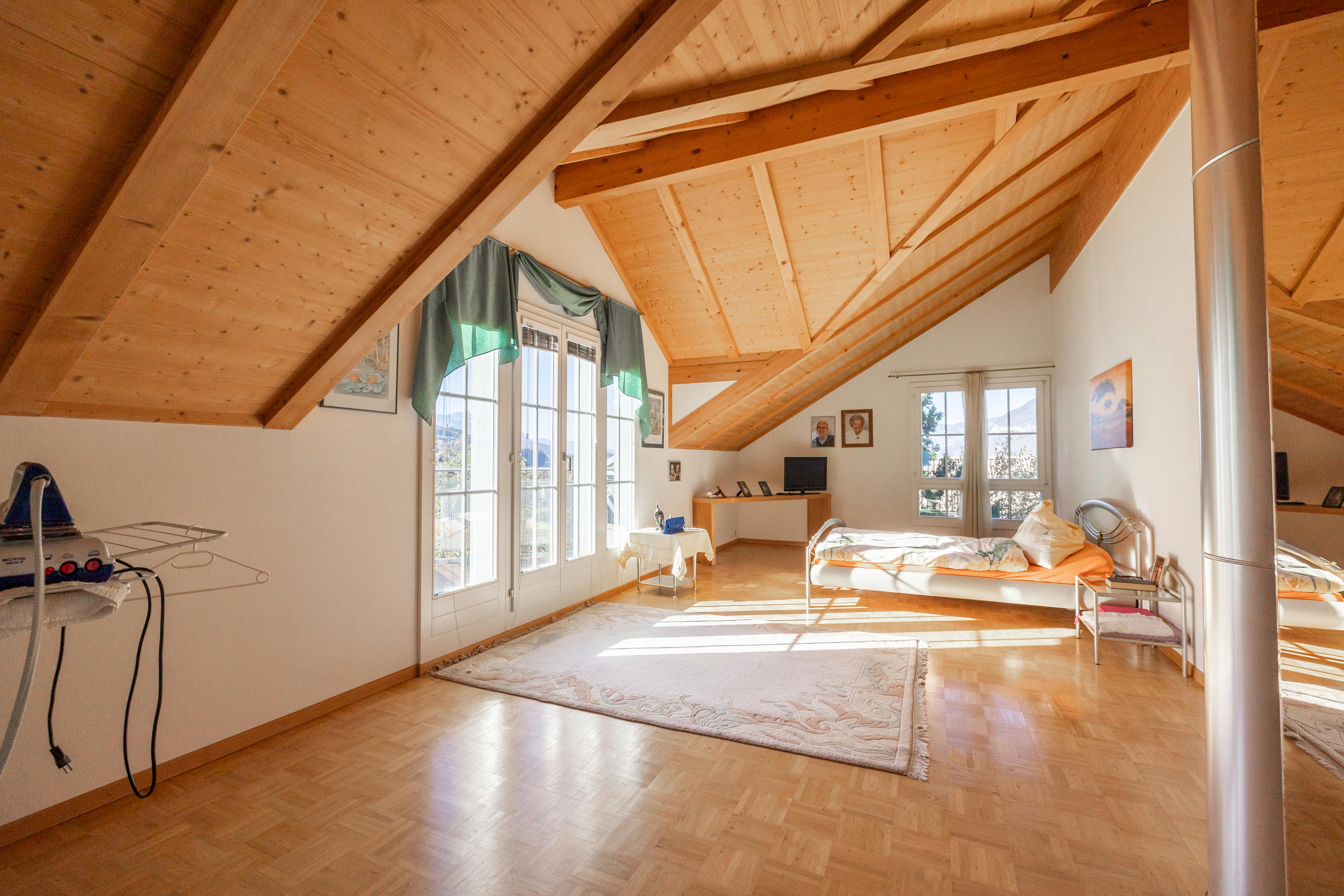Ausgebautes Dachgeschoss-Schlafzimmer mit Holzsichtdach und Blick ins Freie