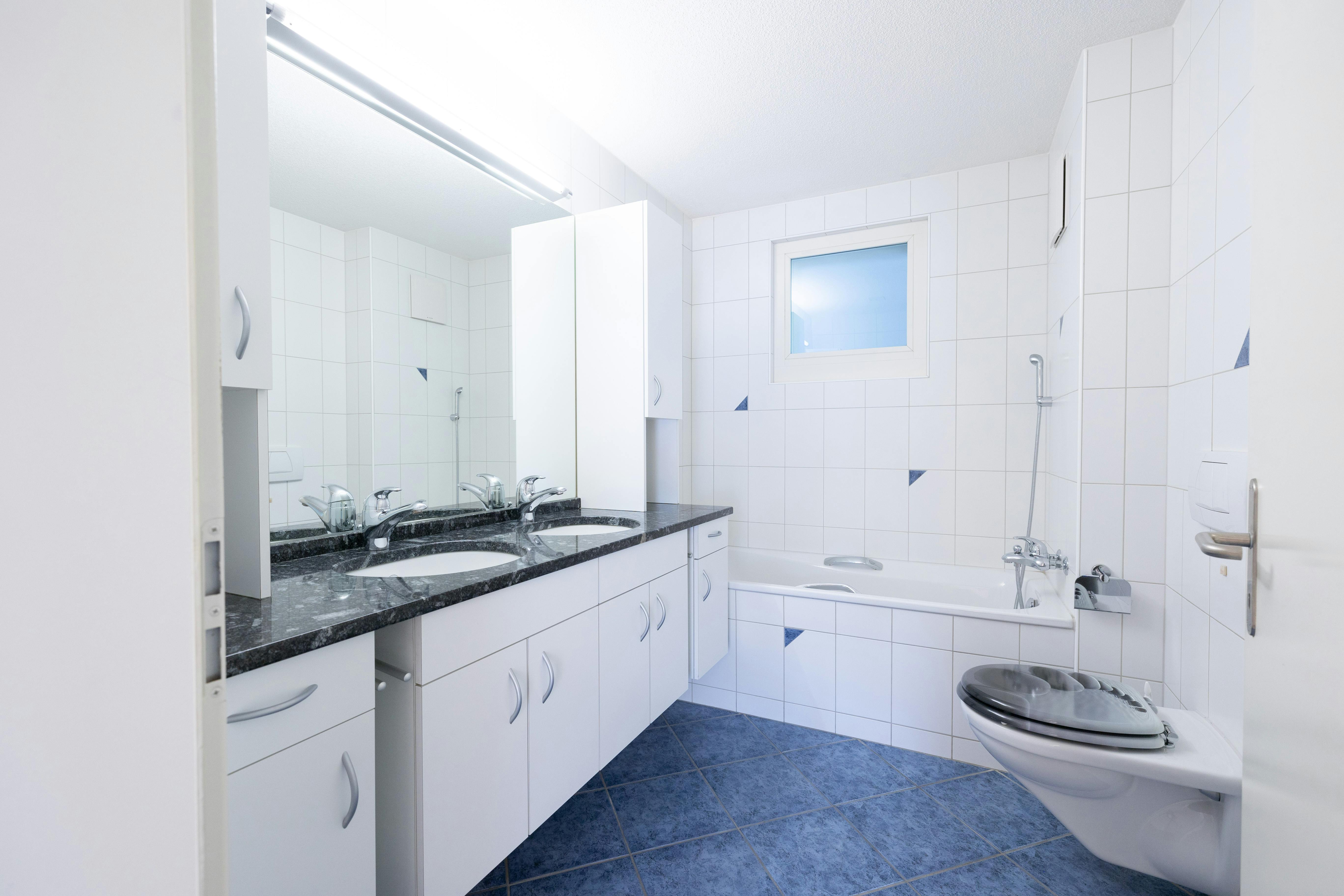 Helles Badezimmer mit Badewanne und Doppelwaschtisch