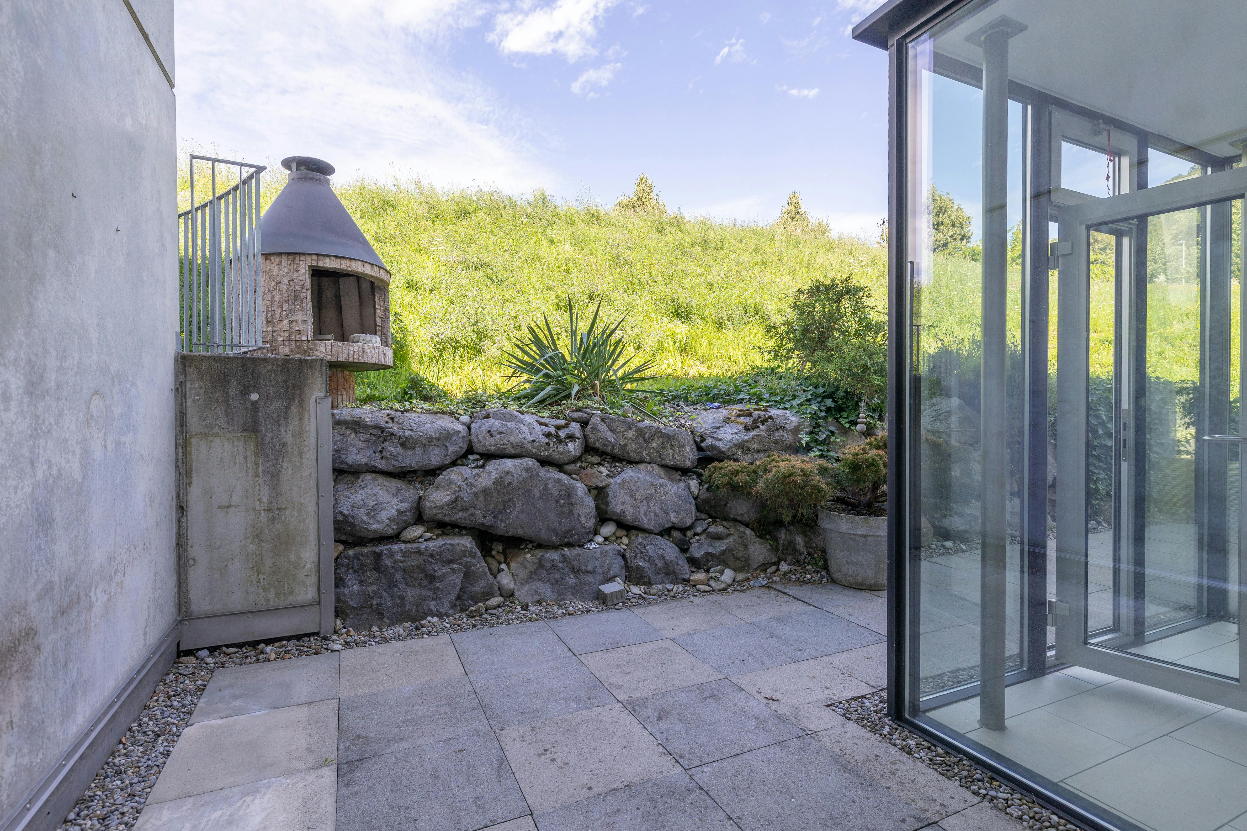 Terrasse mit Außenkamin und Glasfassade