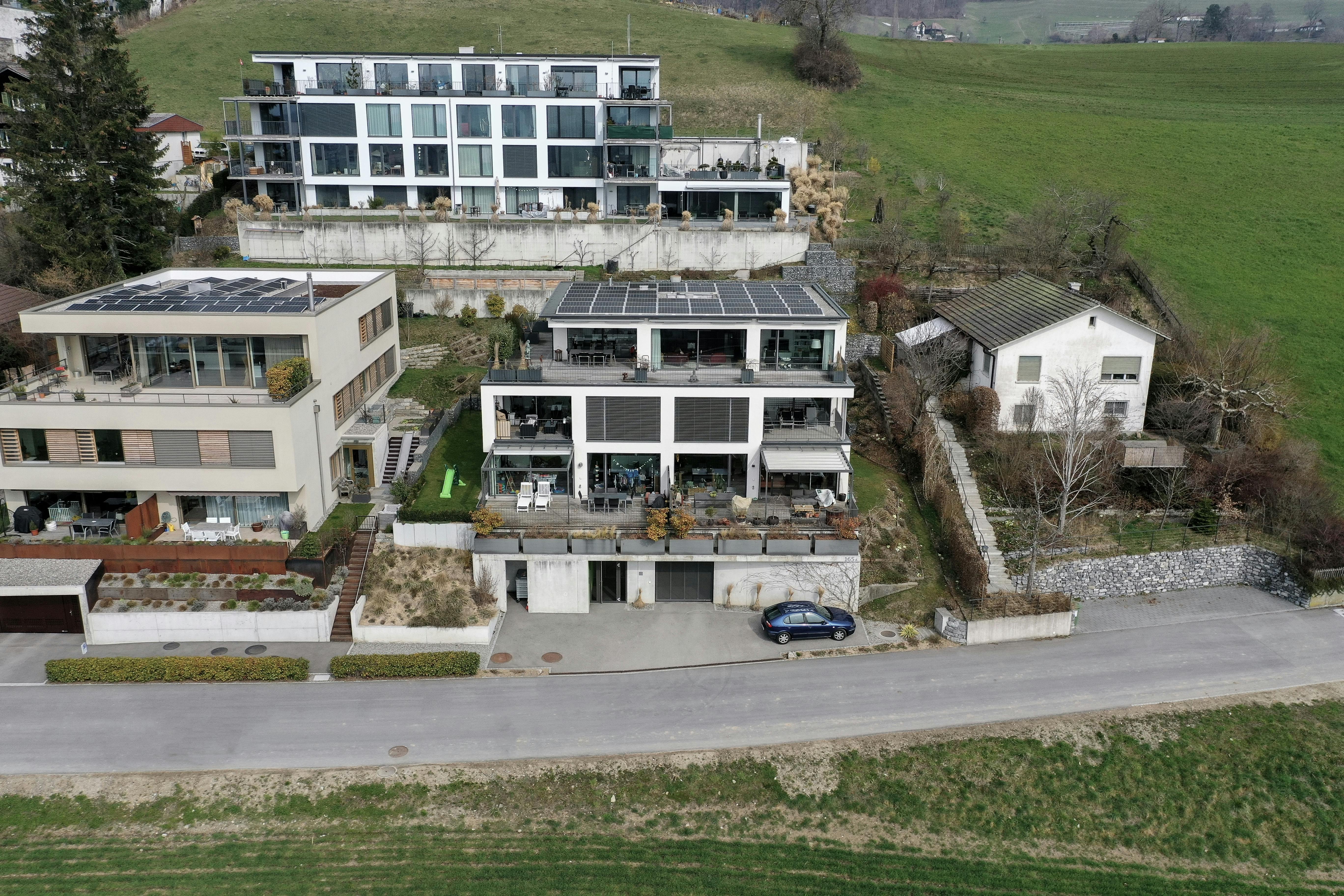 Moderne Wohnhäuser in Hanglage mit Solardächern