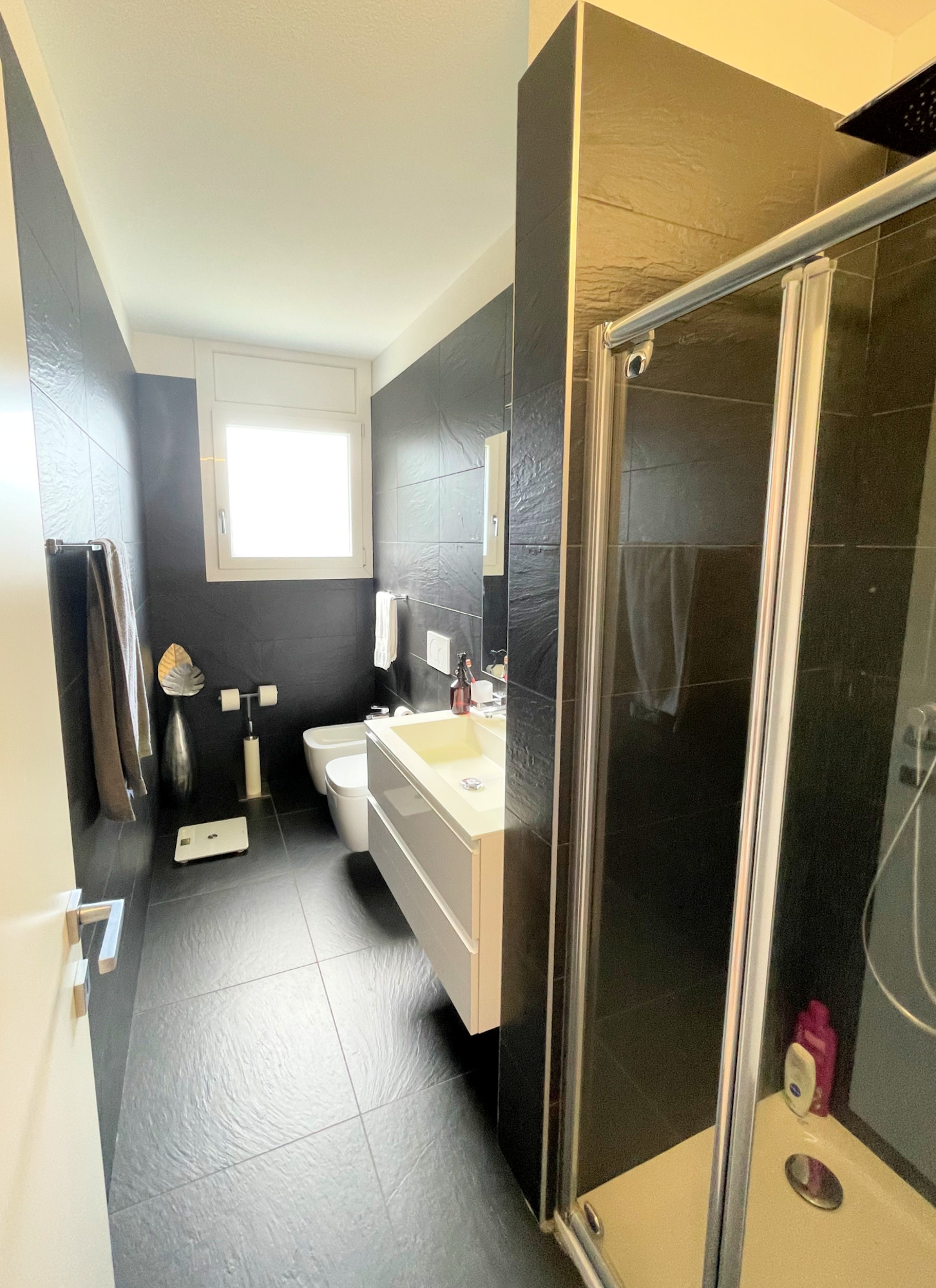 Modernes Badezimmer mit dunklen Fliesen