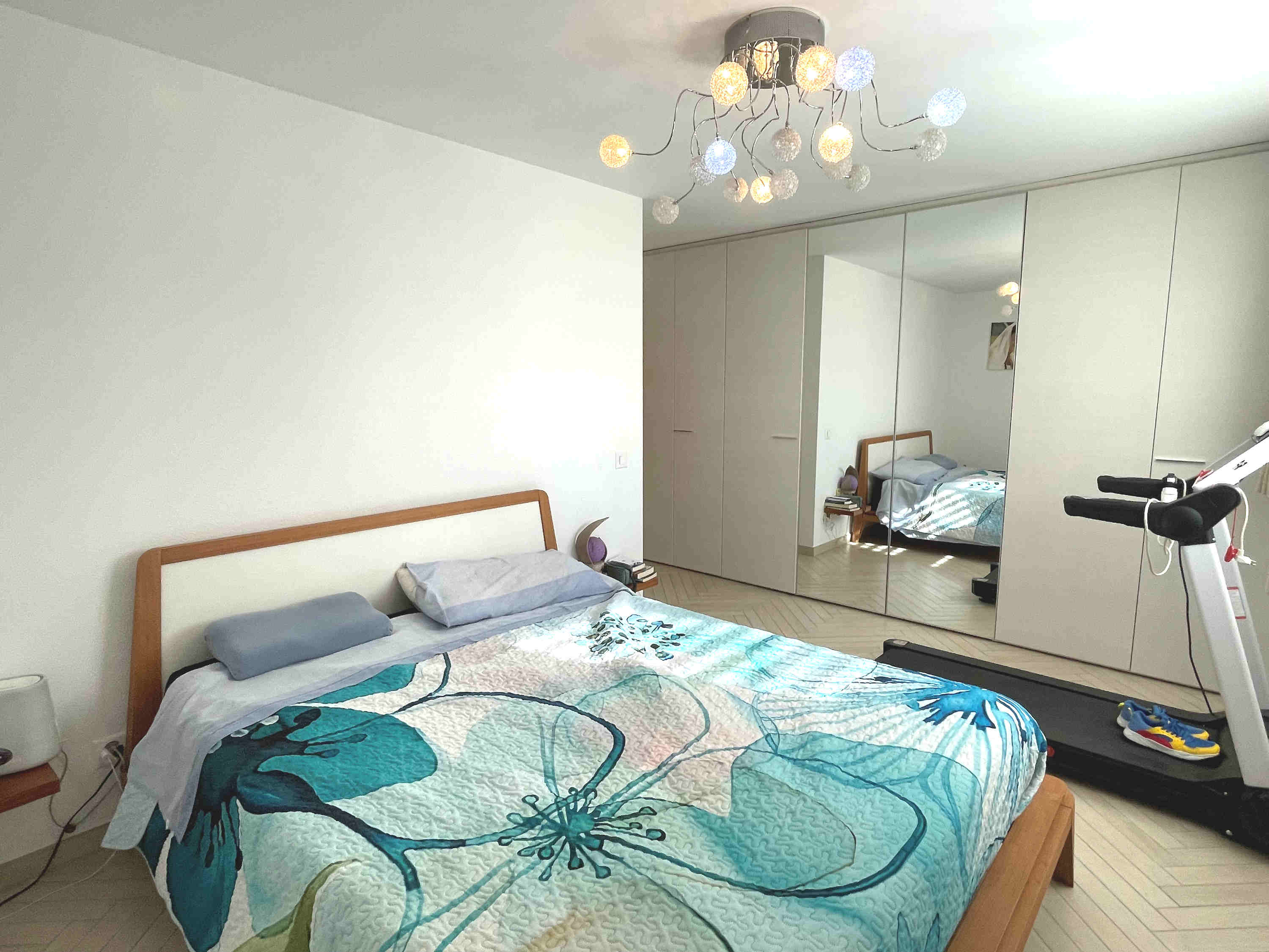 Helles Schlafzimmer mit Einbauschrank und Fitnessgerät