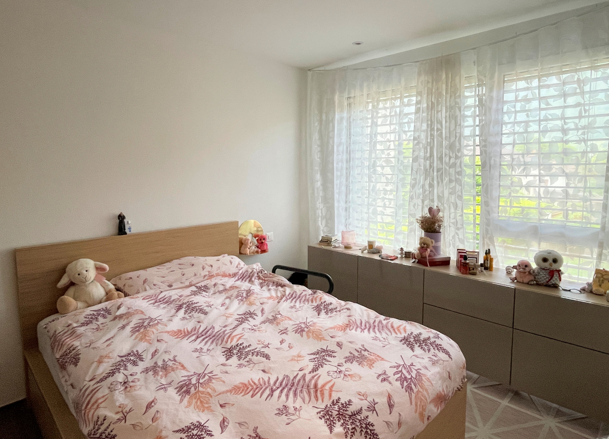 Helles Schlafzimmer mit Doppelbett und Fensterbank