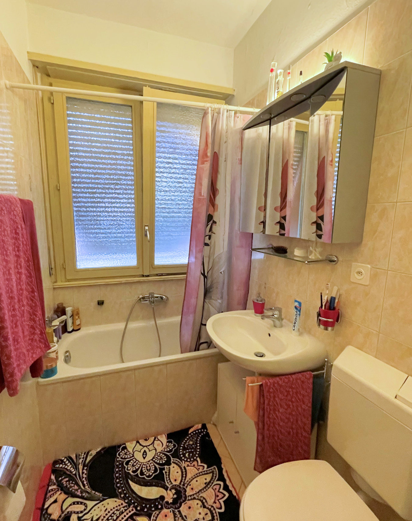 Kleines Badezimmer mit Badewanne und Fenster
