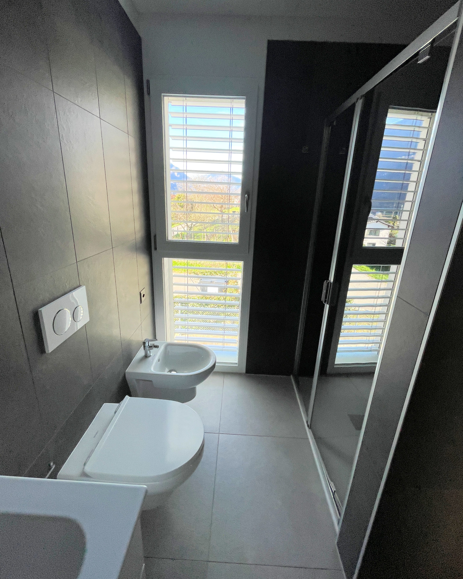 Modernes Badezimmer mit dunklen Wänden und bodentiefem Fenster