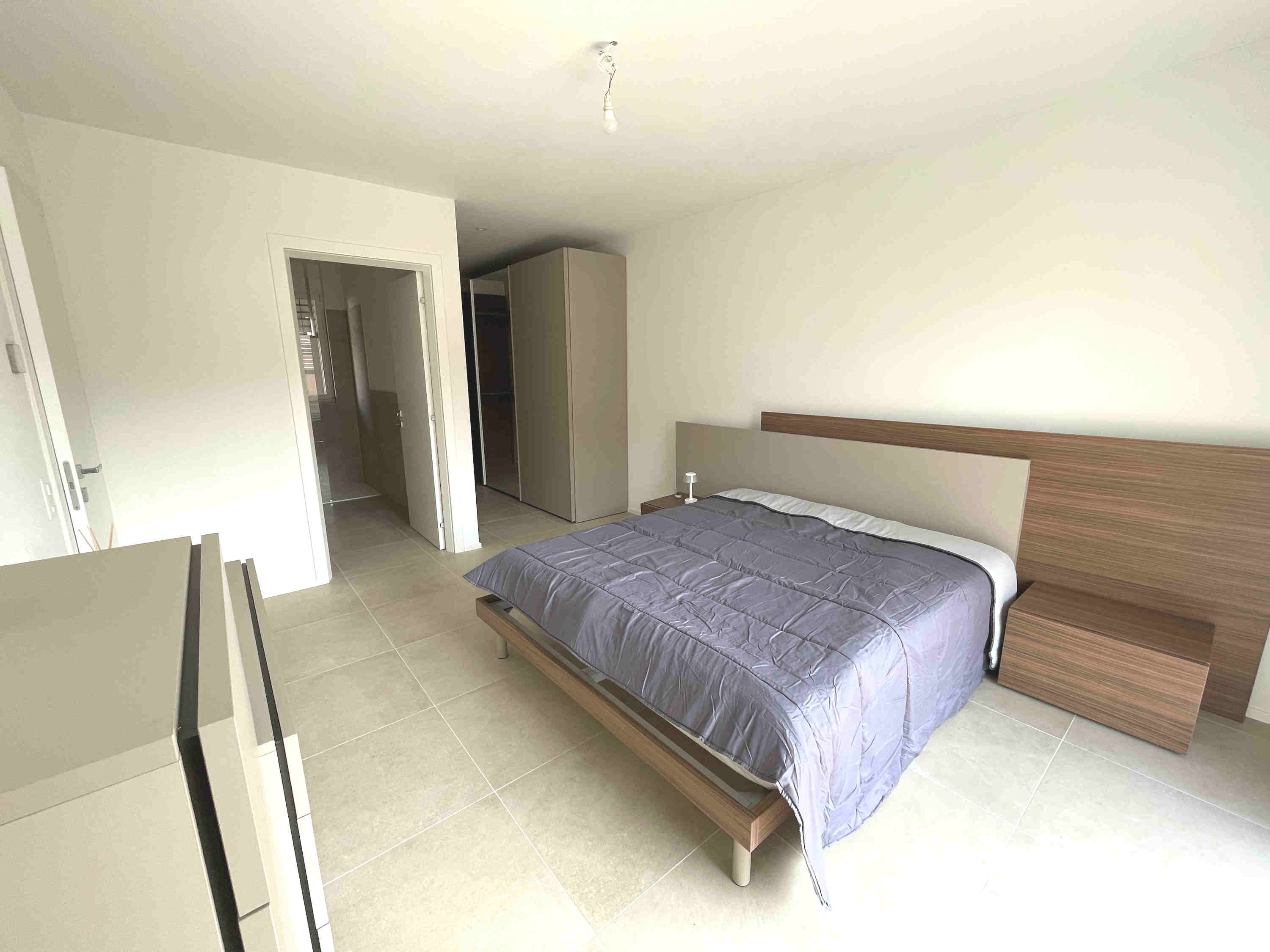 Helles Schlafzimmer mit Doppelbett und Kleiderschrank