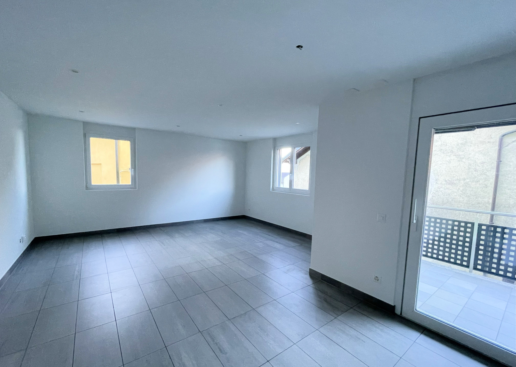 Leerer, modernisierter Wohnraum mit Balkonzugang
