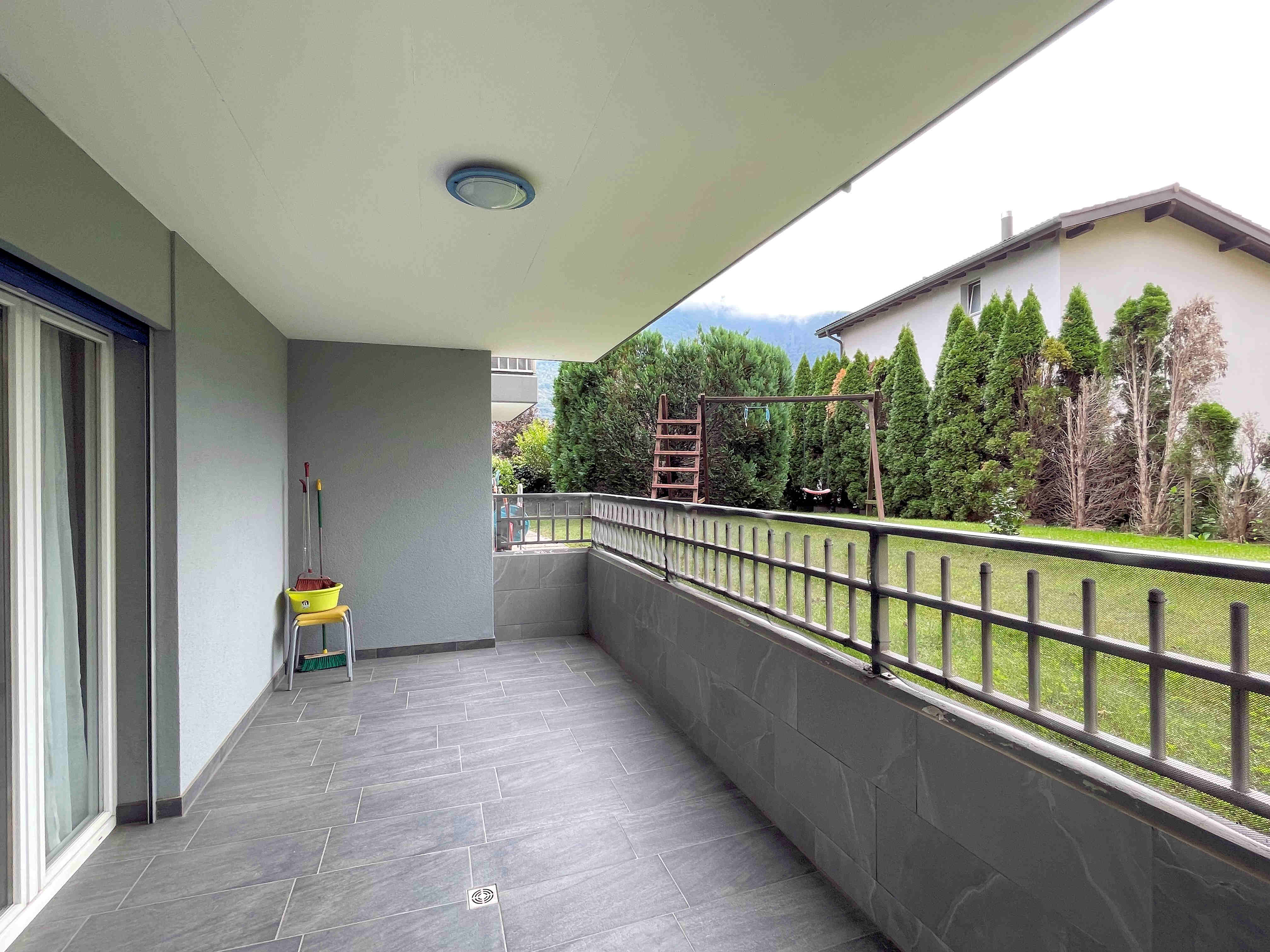 Überdachter Balkon mit Gartenblick