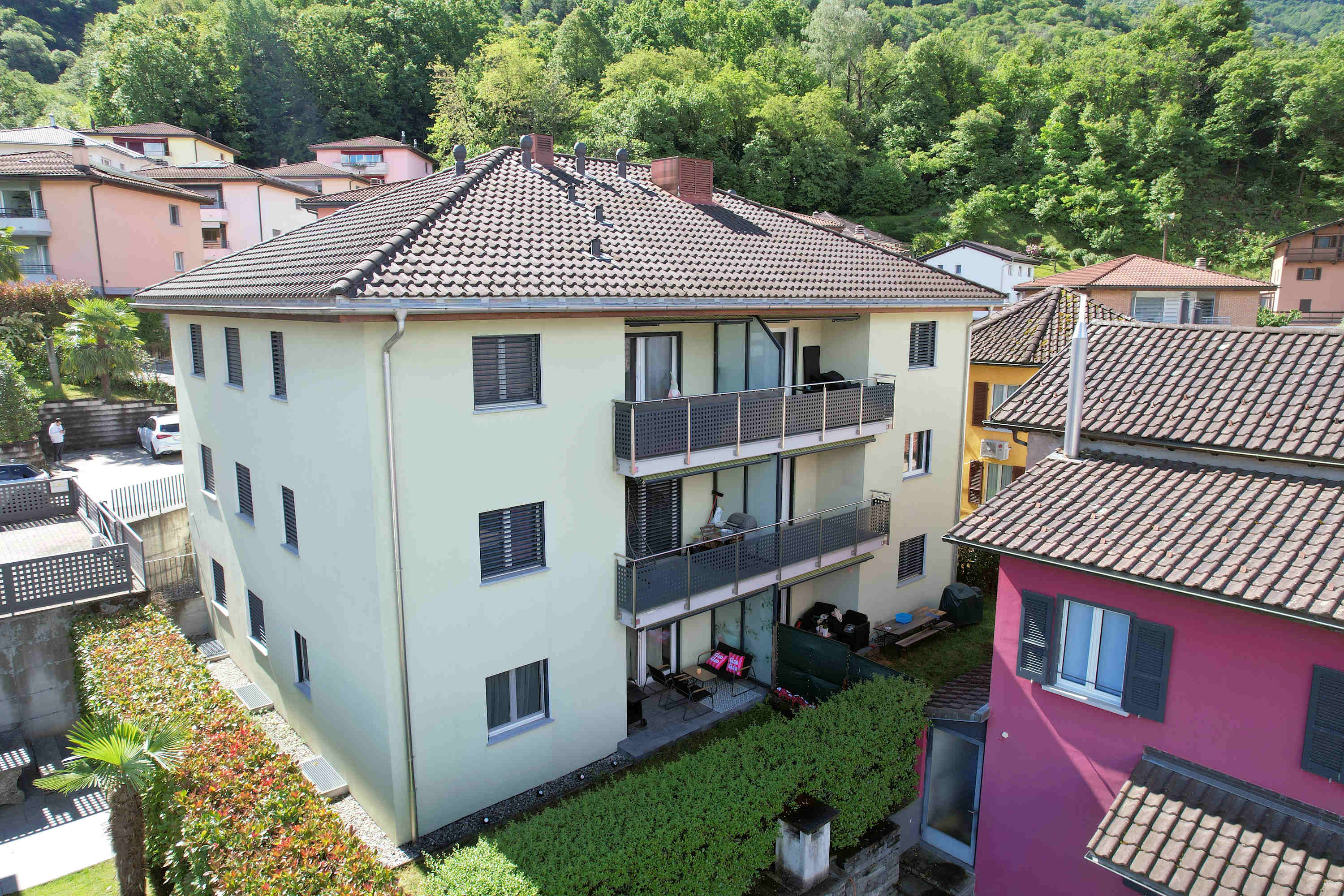 Mehrfamilienhaus mit Balkonen in grüner Hanglage