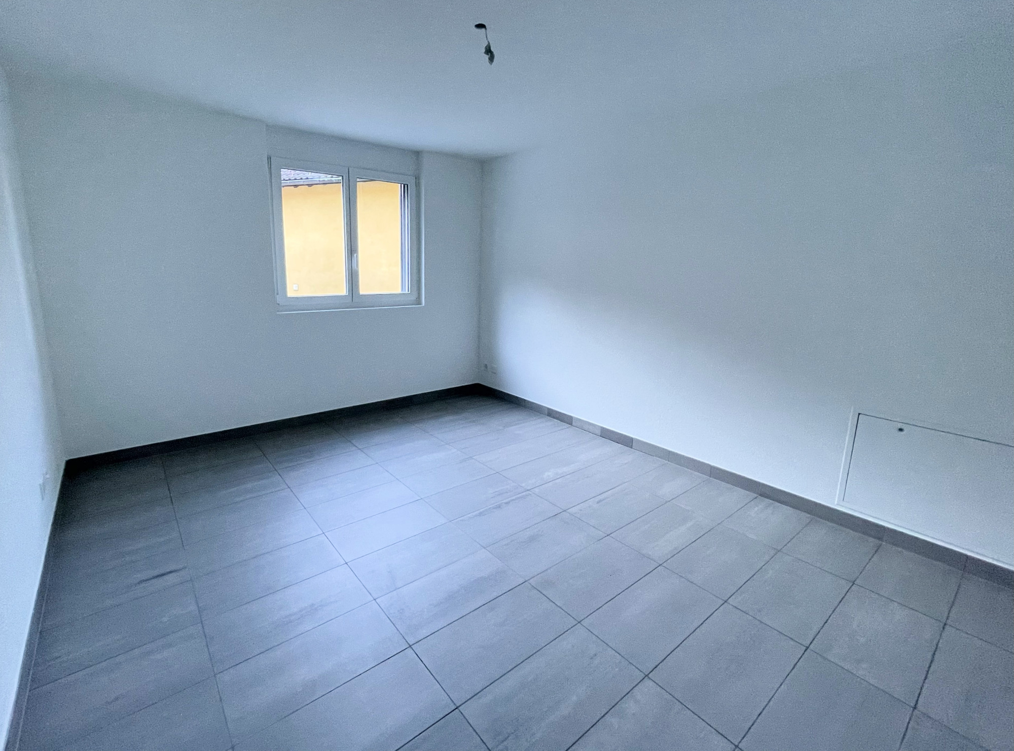 Leeres Zimmer mit Fliesenboden und Fenster