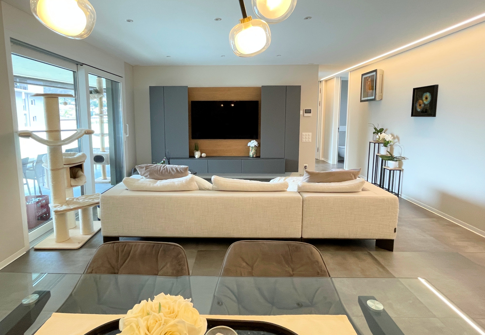 Modernes Wohnzimmer mit TV-Wand und Katzenbaum
