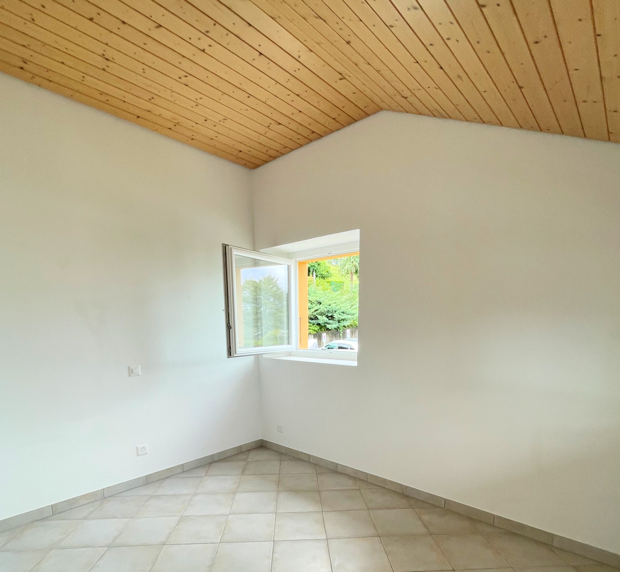 Leerer Raum mit Fliesenboden und Holzdecke