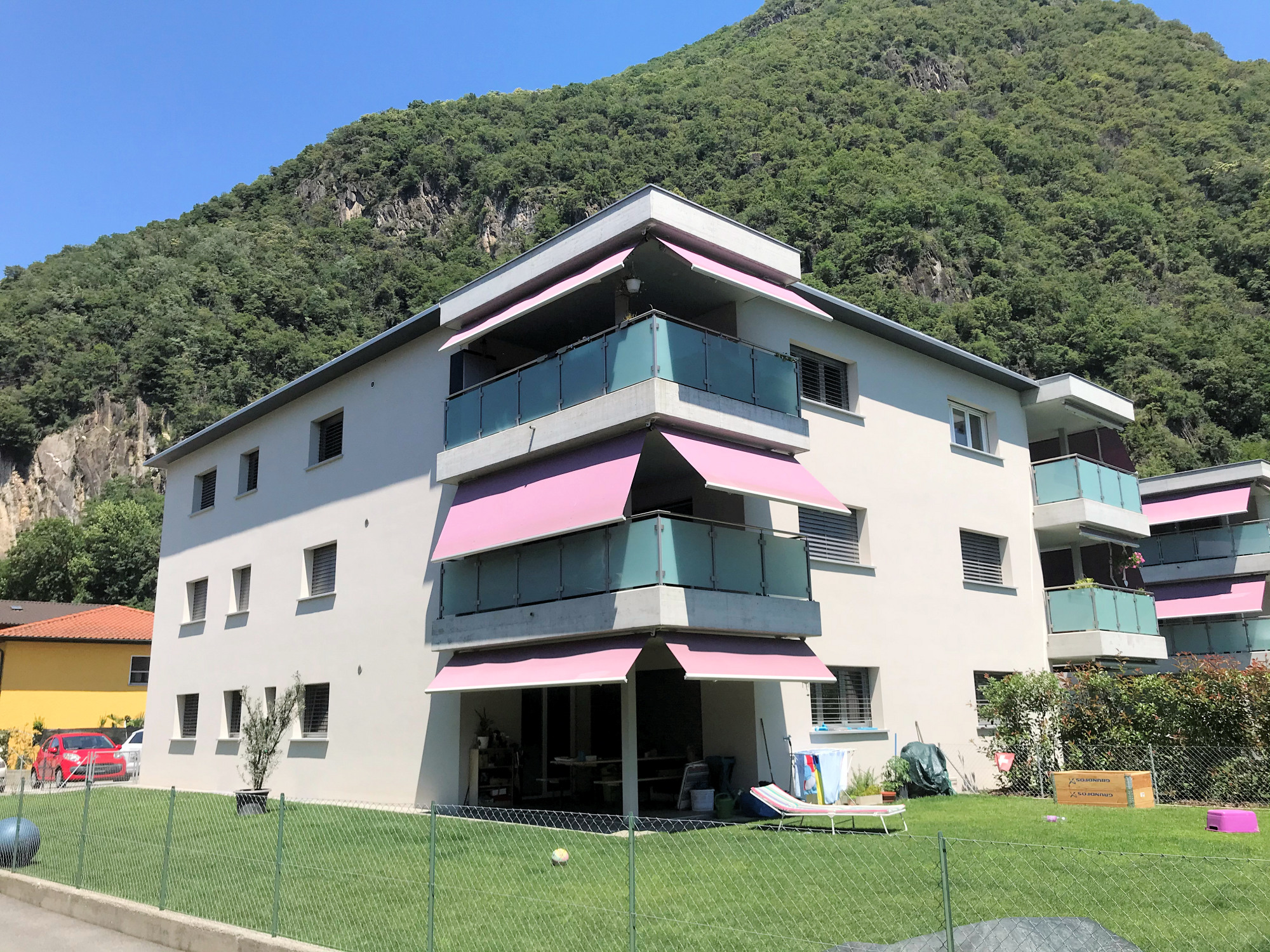 Wohnhaus mit Balkonen vor Bergkulisse