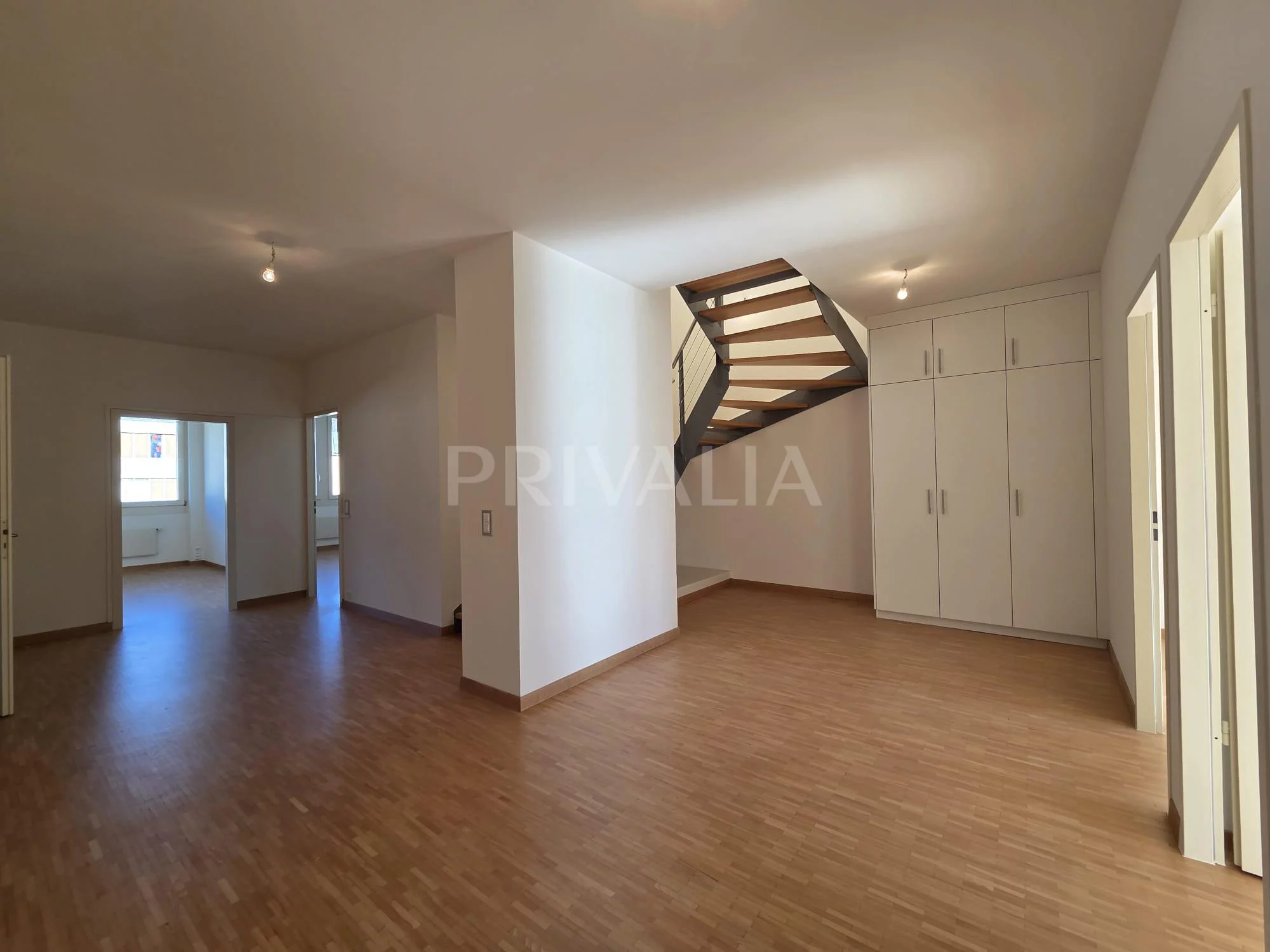 Heller leerer Wohnraum mit Treppe und Einbauschränken