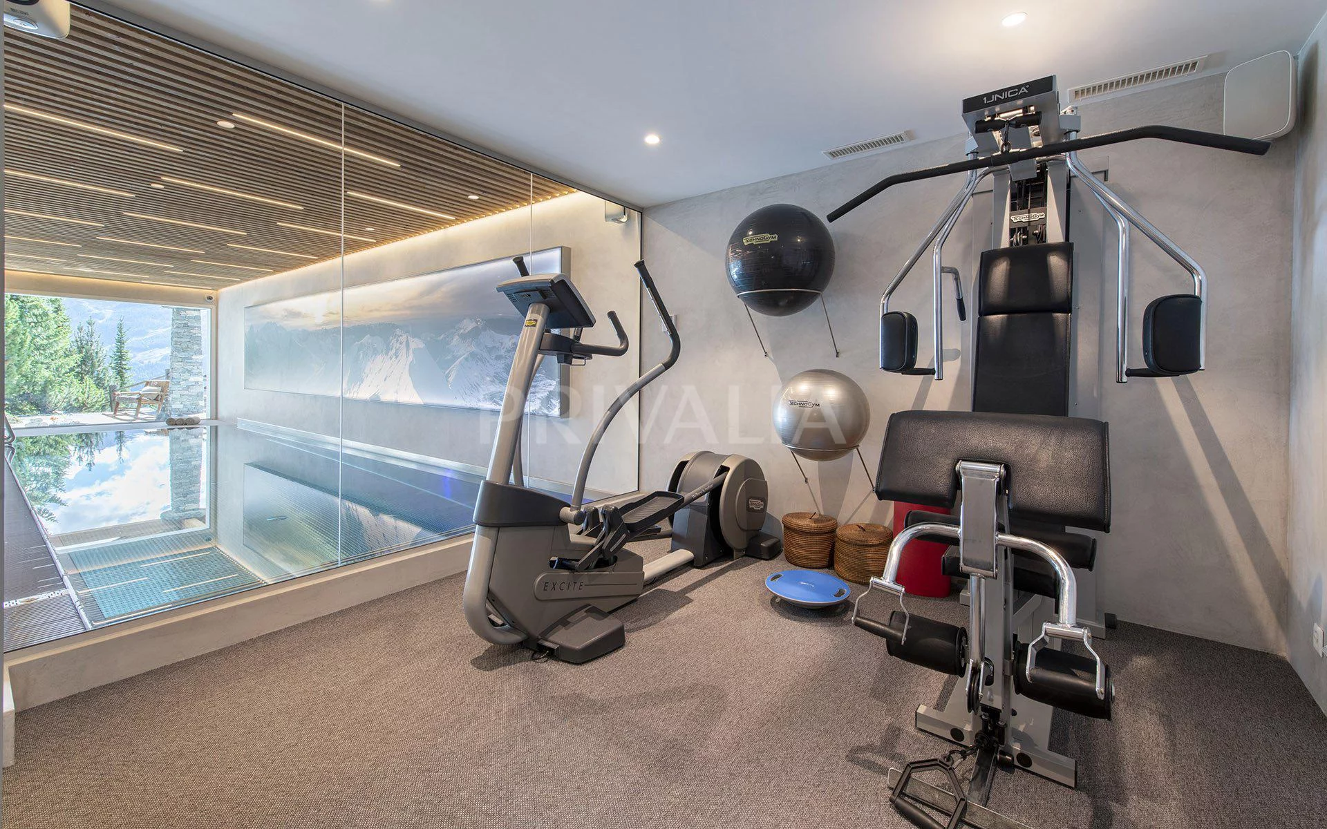 Luxuriöser Fitnessraum mit Indoor-Poolblick