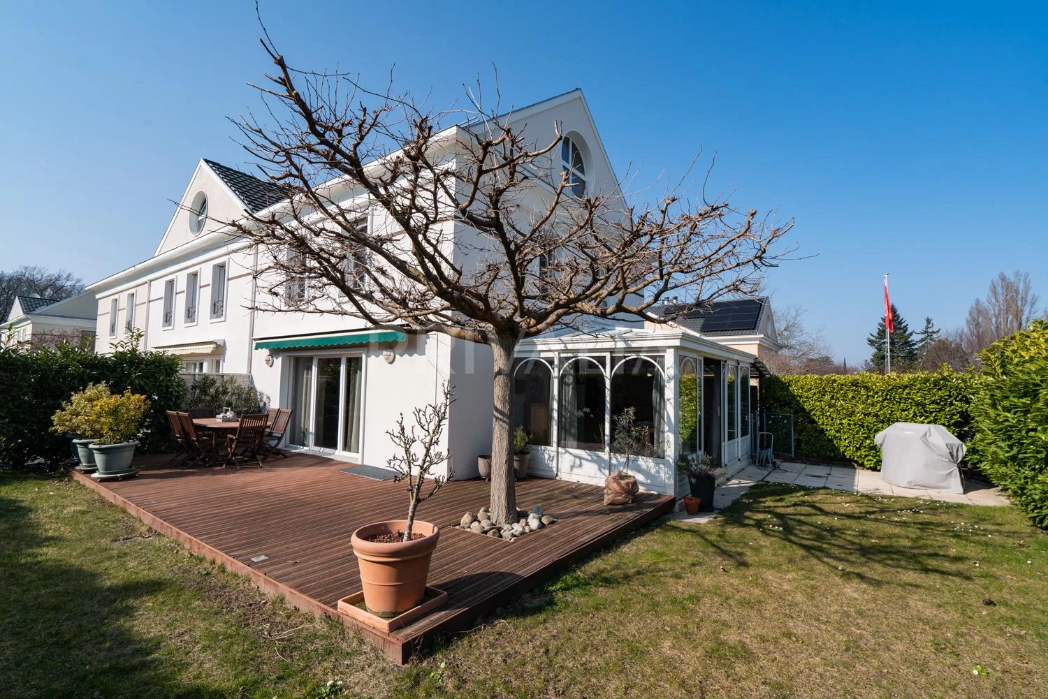 Weiße Villa mit Garten und Holzdeck