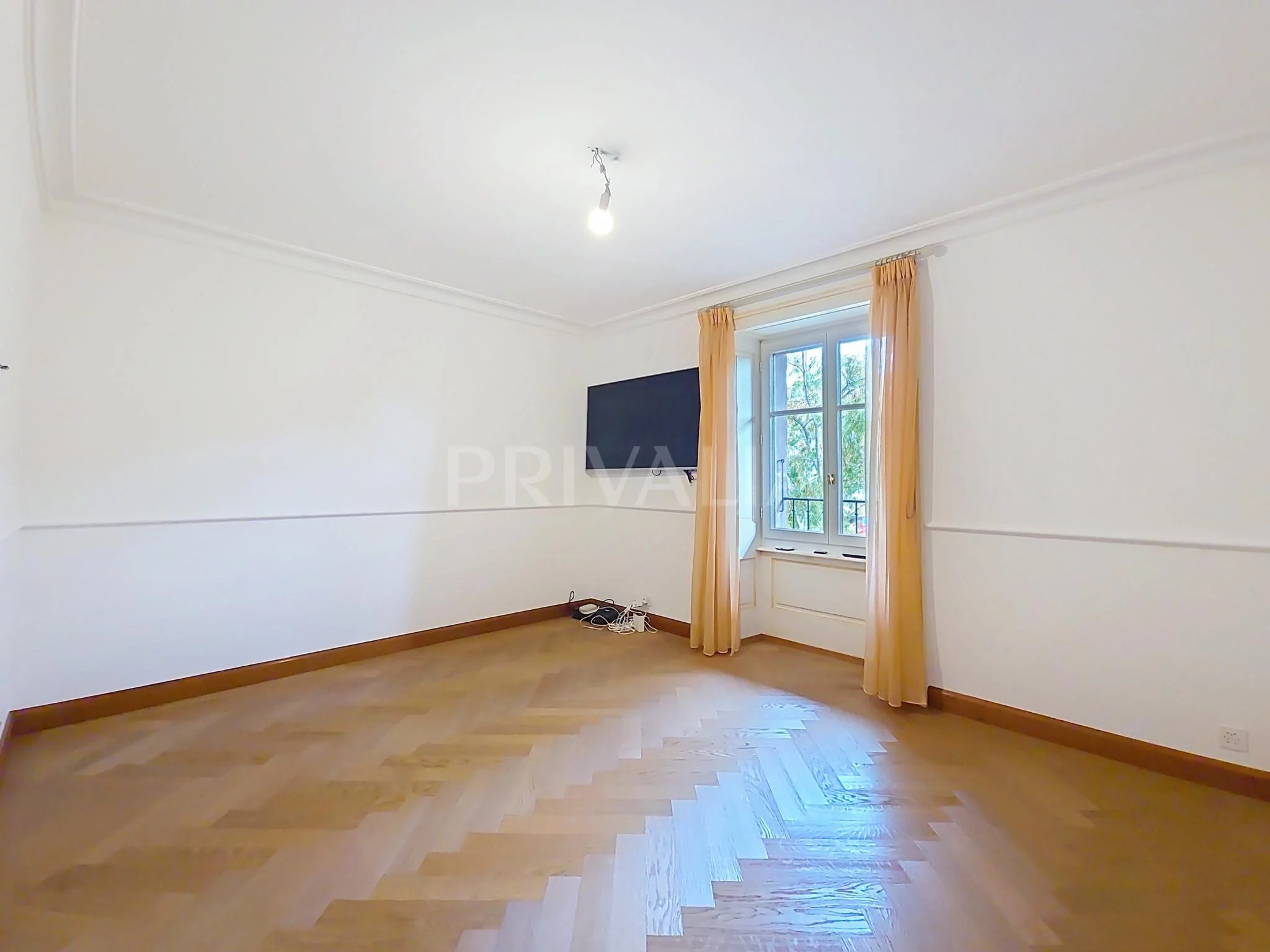 Leerer heller Raum mit Fenster und Parkettboden