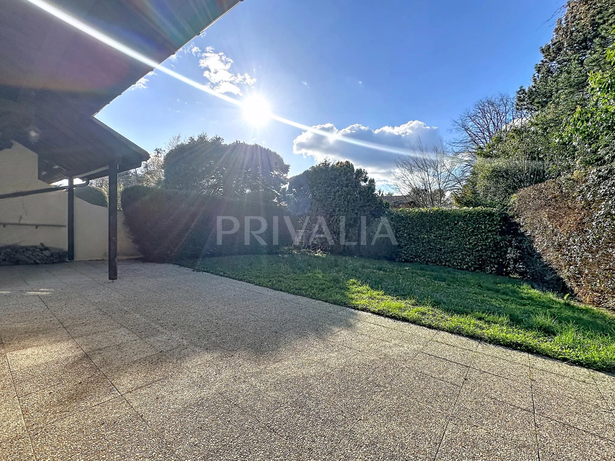 Sonnige Terrasse mit Gartenblick
