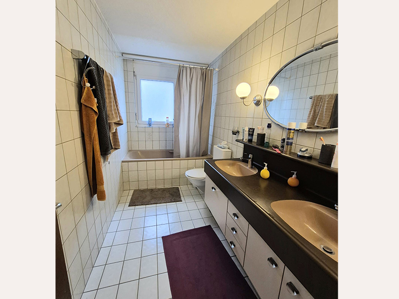 Badezimmer mit Doppelwaschtisch und Badewanne