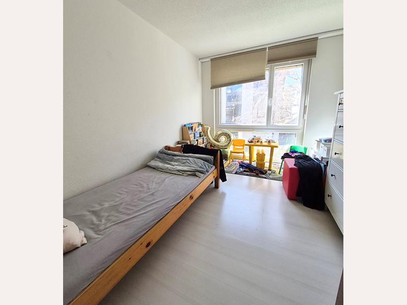 Helles Schlafzimmer mit Einzelbett und Fenster
