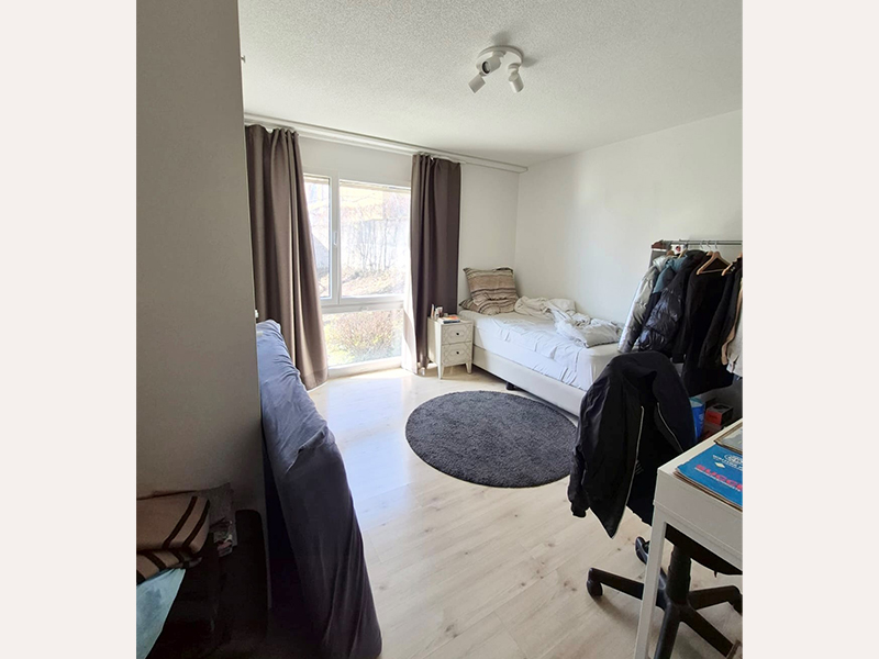 Helles Schlafzimmer mit Fenster und Einzelbett