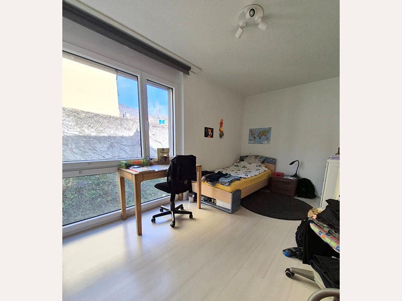 Helles Schlafzimmer mit Schreibtisch und Bett