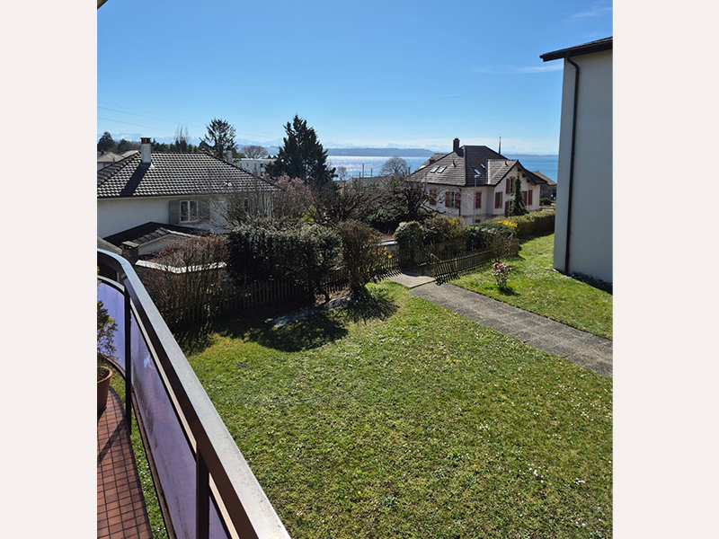 Balkon- bzw. Gartenblick auf Wohnhäuser und See
