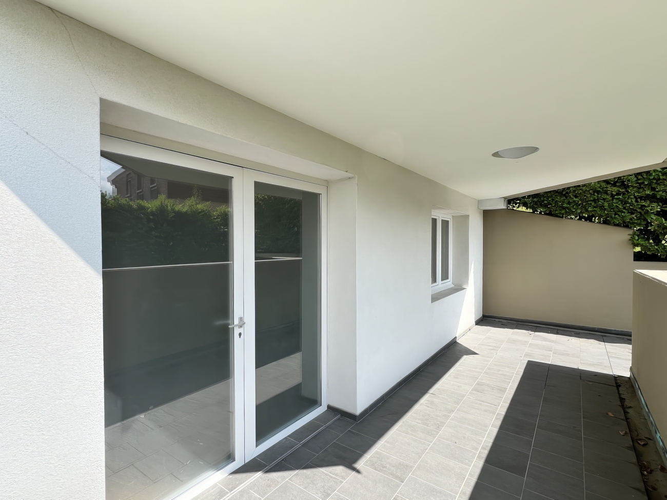 Überdachte Terrasse mit Fliesenboden