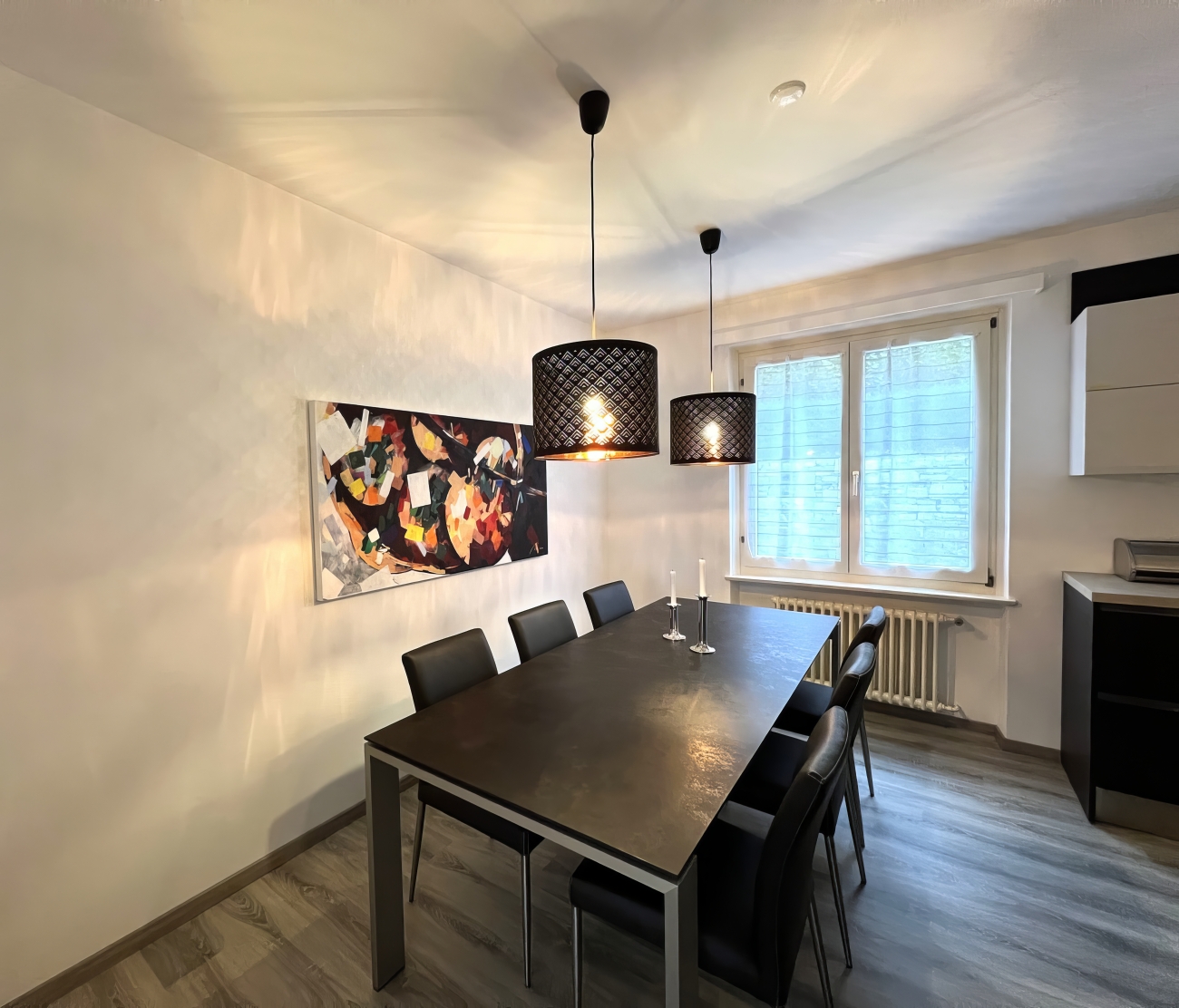 Esszimmer mit dunklem Tisch und Pendelleuchten