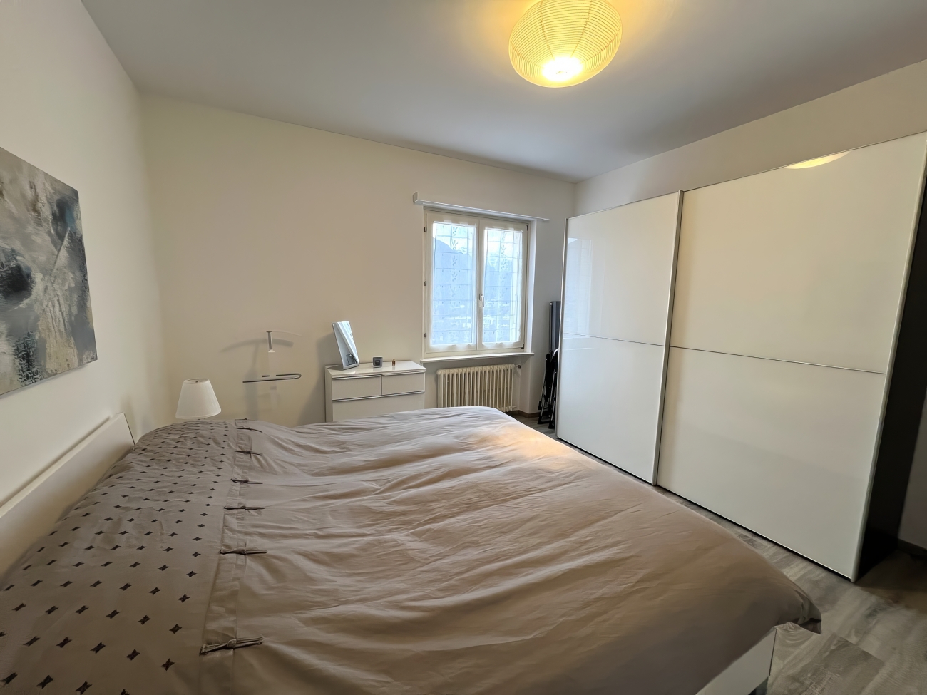 Schlafzimmer mit großem Bett und Schrankwand
