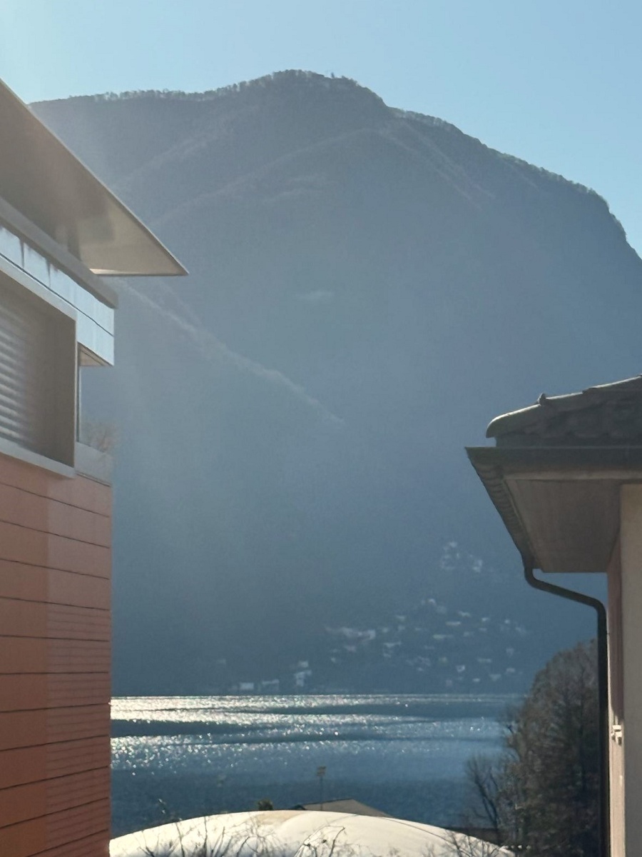 Seeblick mit Bergen zwischen Gebäuden