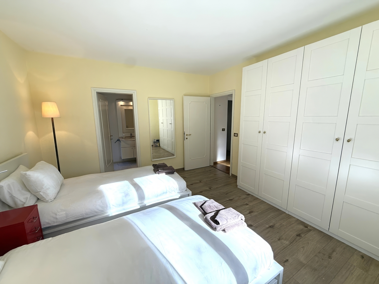 Helles Schlafzimmer mit Doppelbett und großem Kleiderschrank