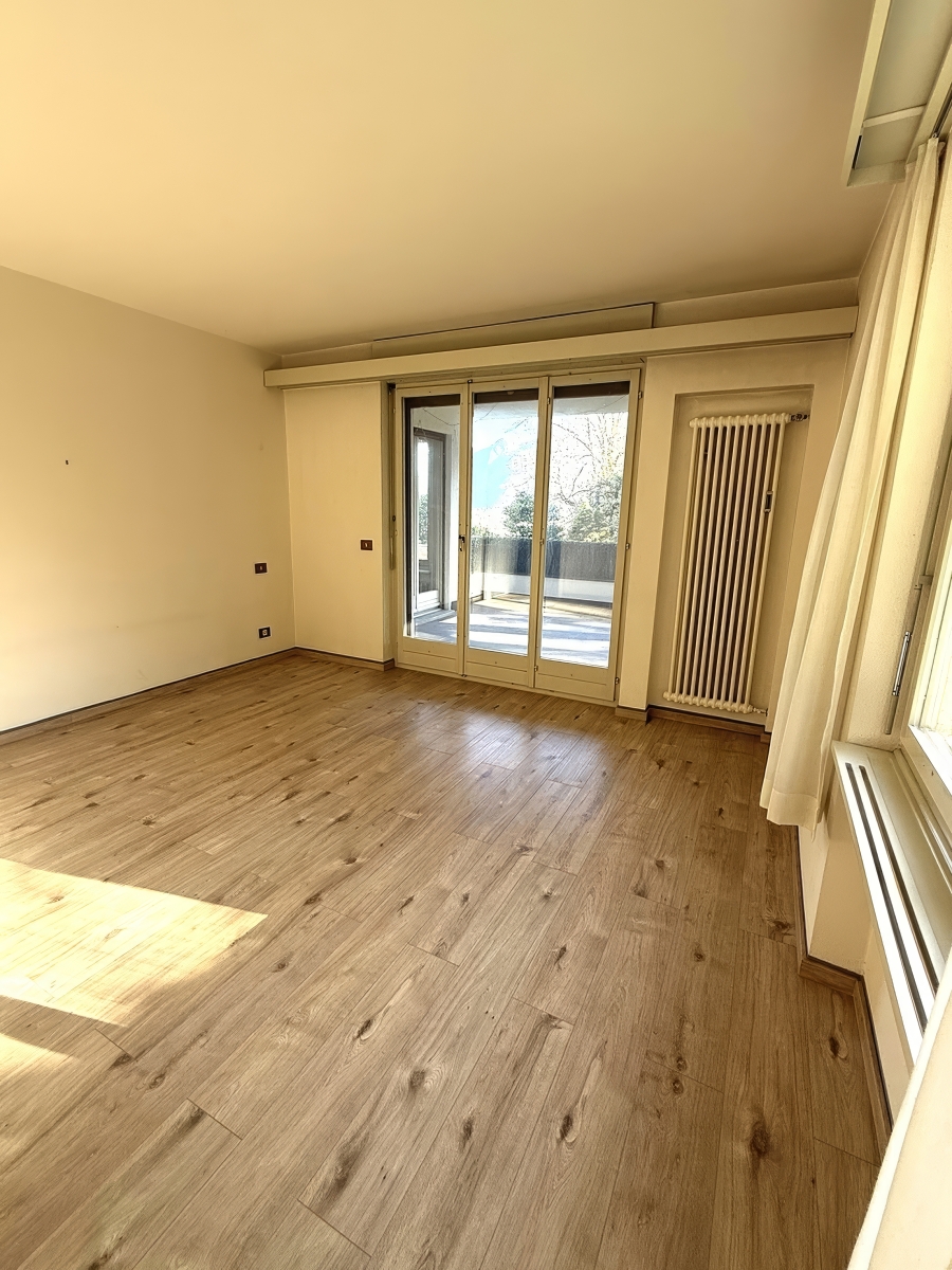 Leeres Wohnzimmer mit Terrassentür und Heizkörper