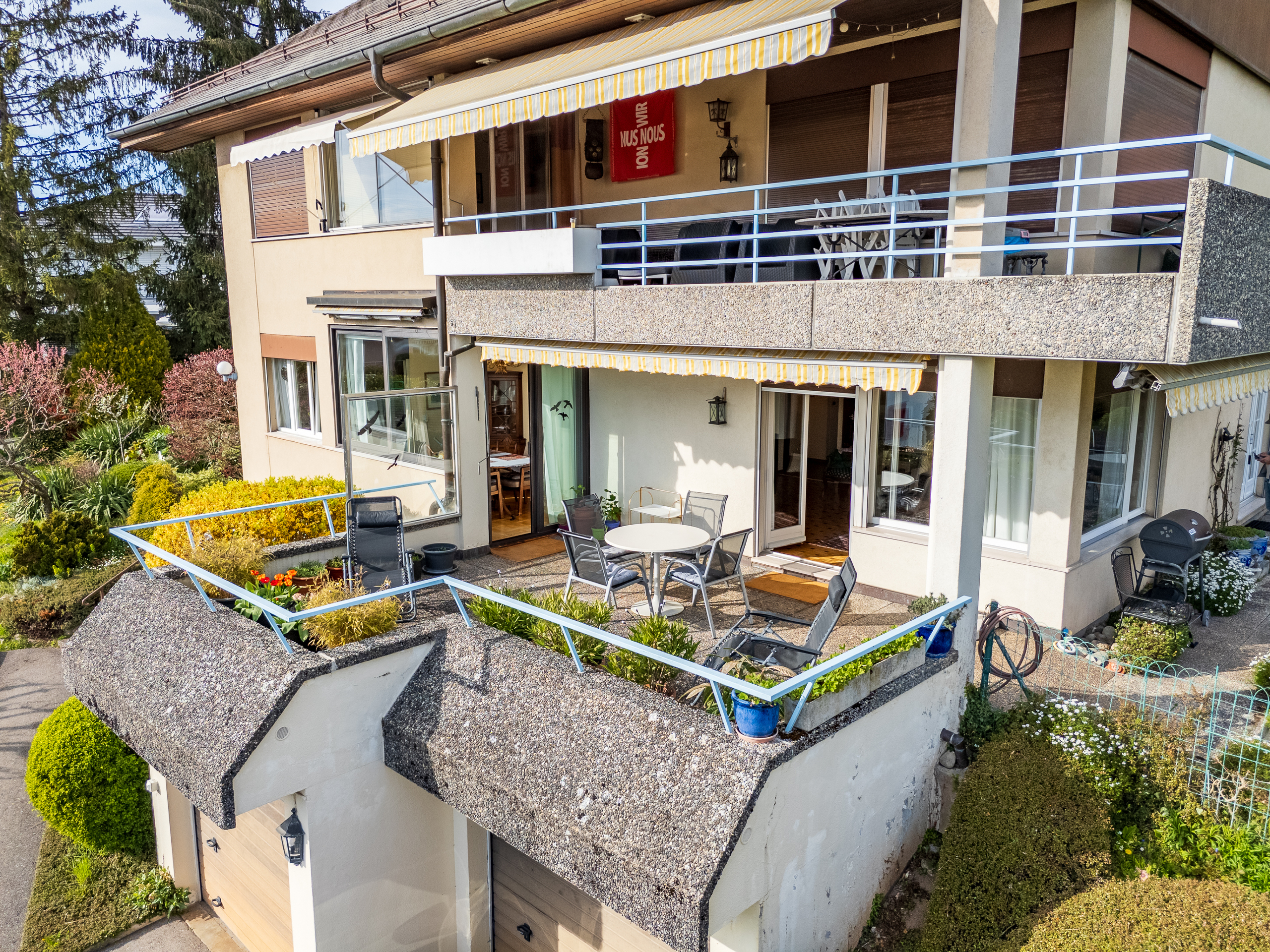 Außenansicht eines Mehrfamilienhauses mit Terrasse und Garten