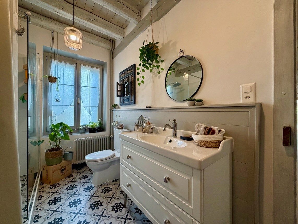 Helles, stilvolles Badezimmer mit Waschkommode und Fenster