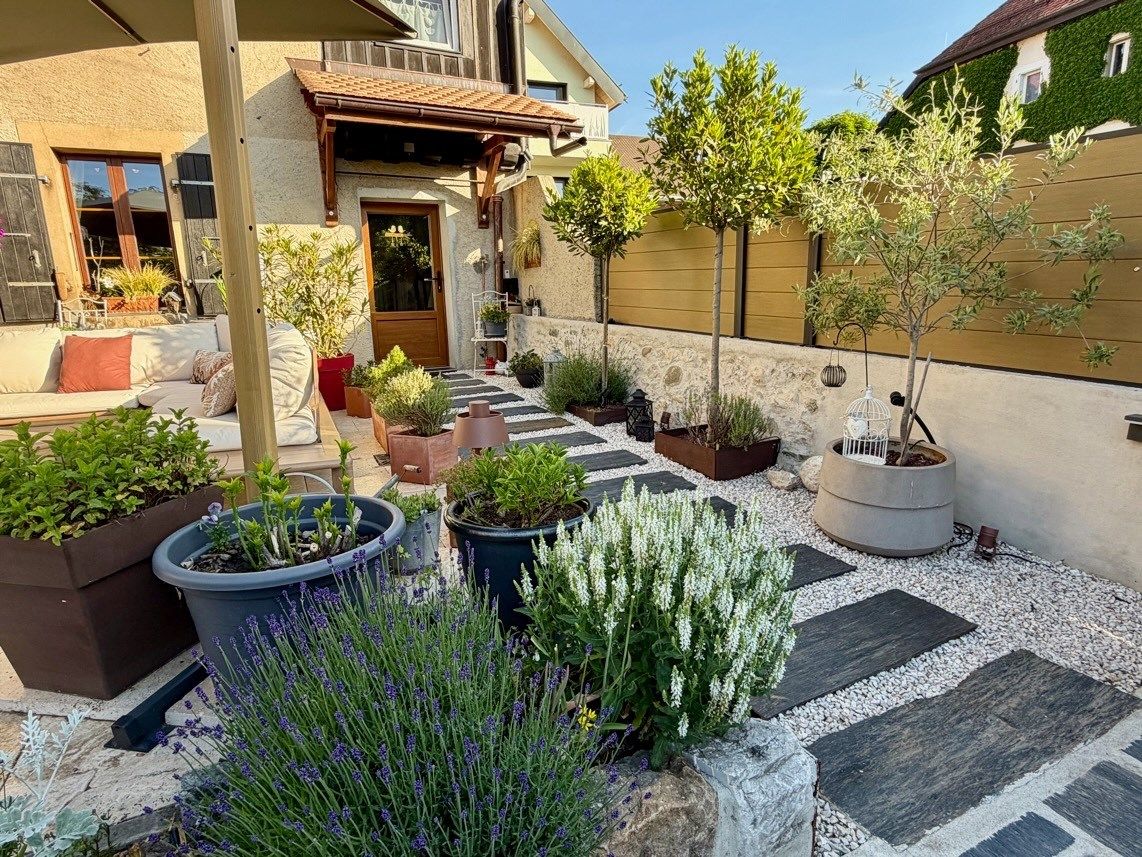 Mediterraner Garten mit Sitzbereich und Pflanzkübeln