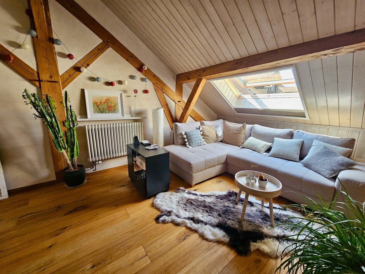 Gemütliches Dachgeschoss-Wohnzimmer mit sichtbaren Holzbalken