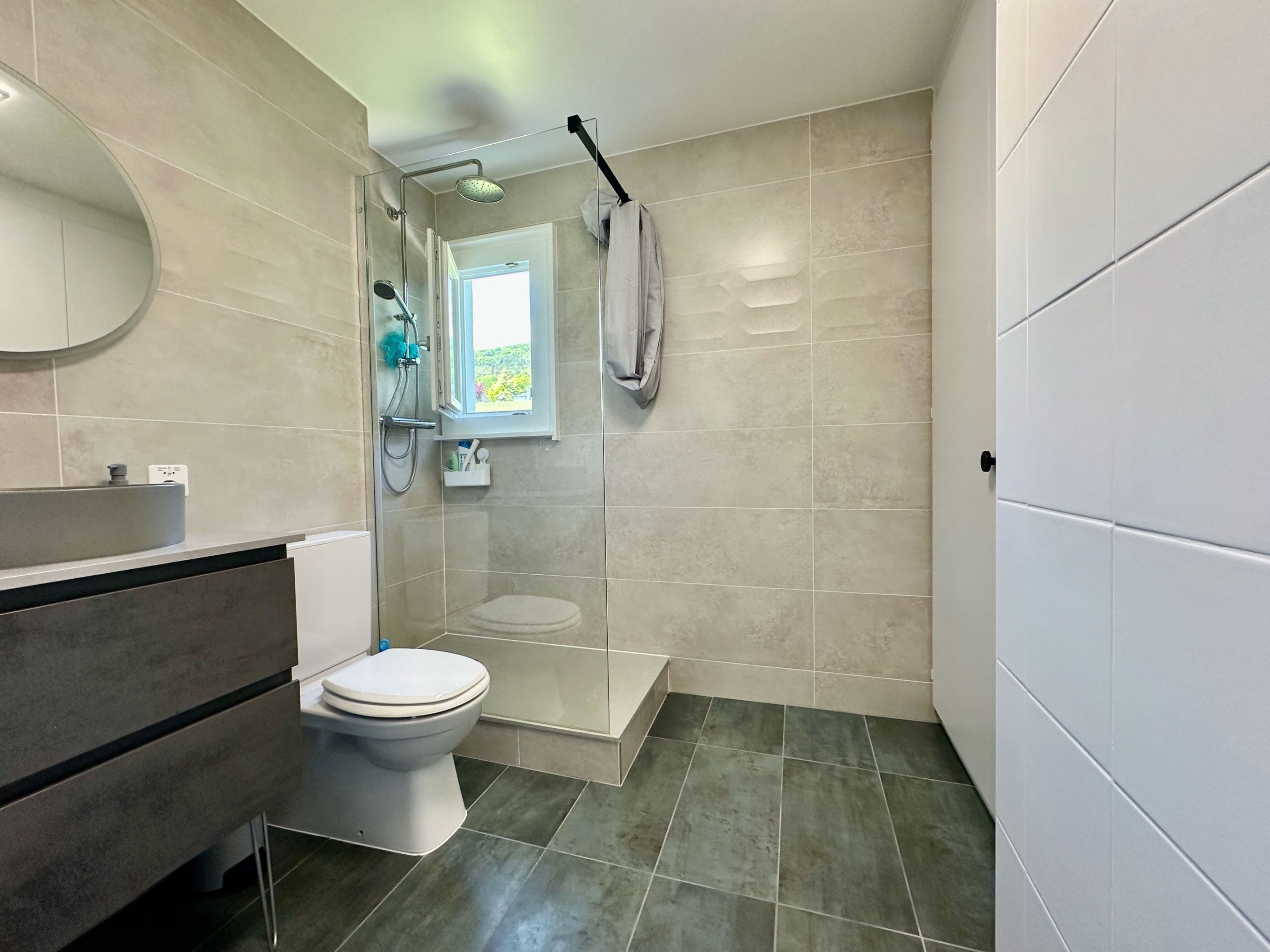 Modernes Badezimmer mit bodengleicher Dusche und WC