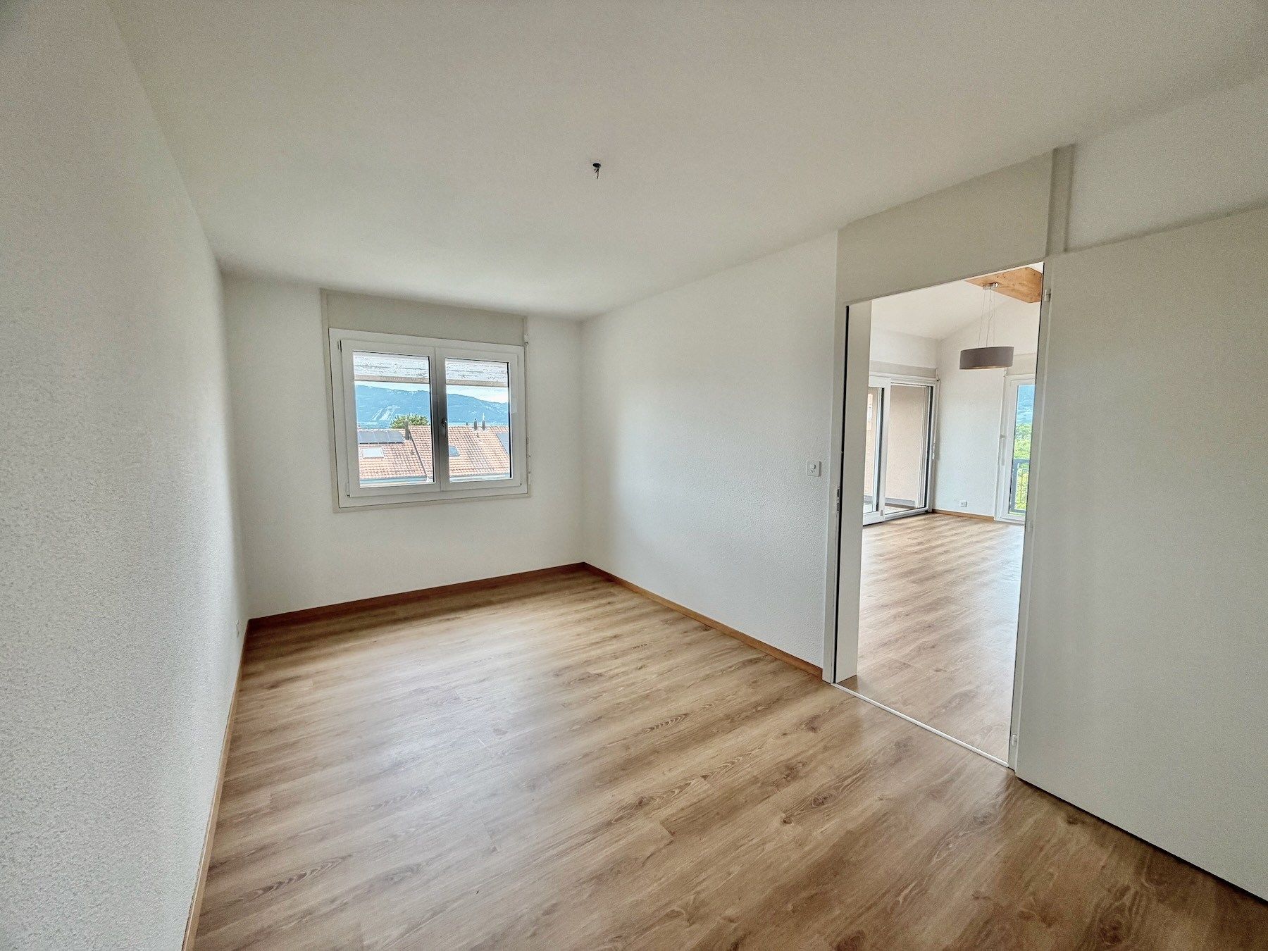 Helles, leeres Schlafzimmer mit Bergblick