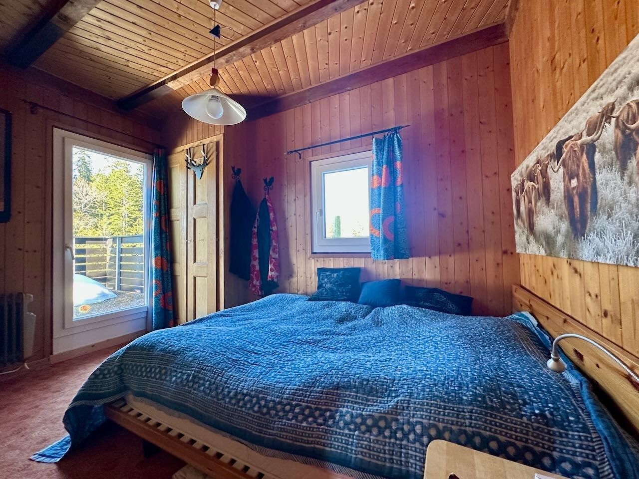 Gemütliches Holzschlafzimmer mit Balkonblick