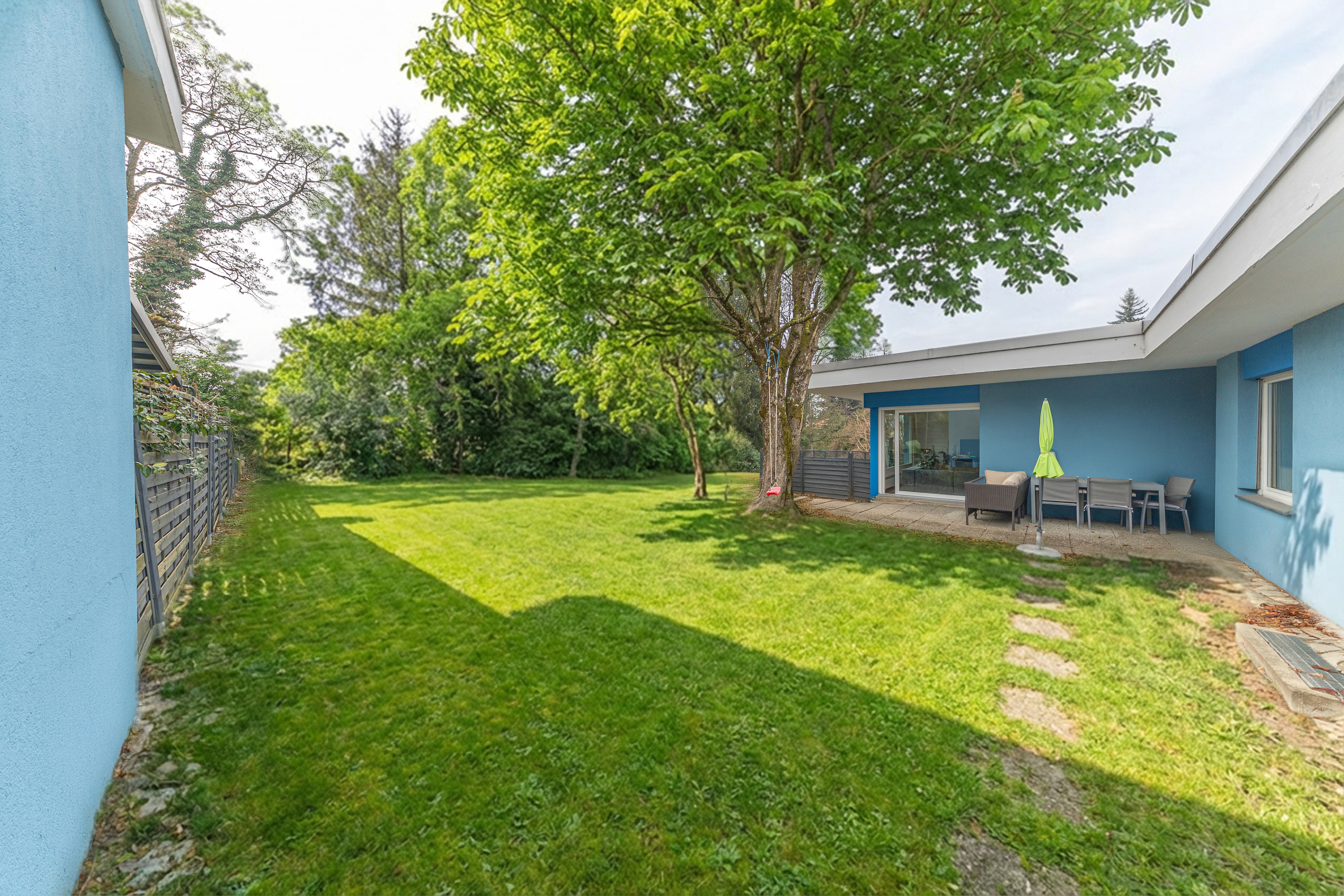 Großer Garten mit Terrasse vor modernem Haus