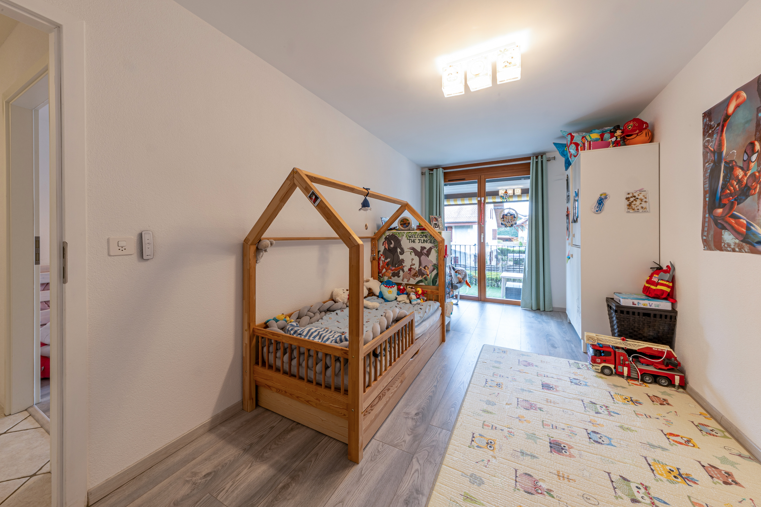 Kinderzimmer mit Spielbett und Balkonzugang