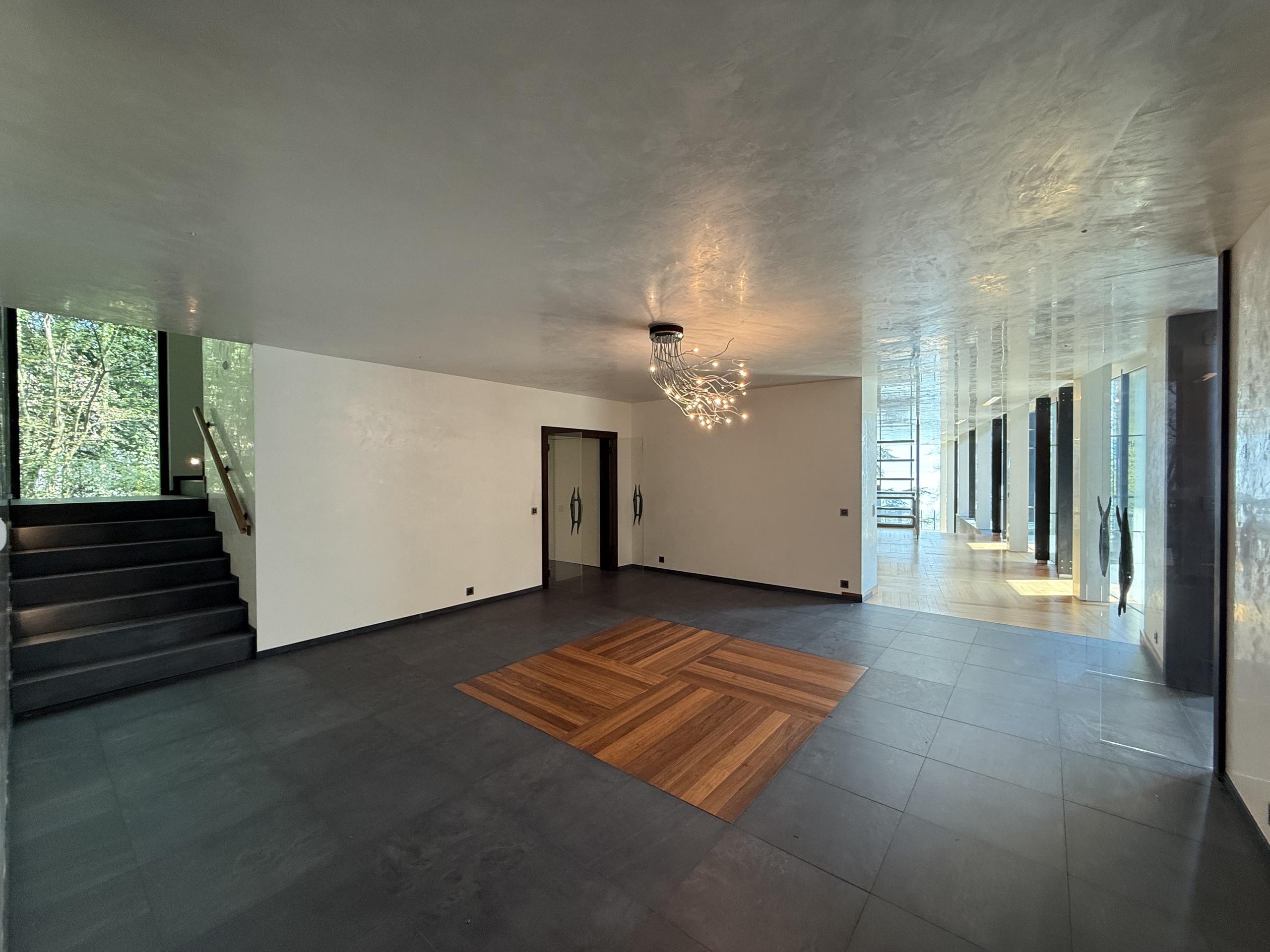 Moderner Eingangsbereich mit Treppe und Designleuchte