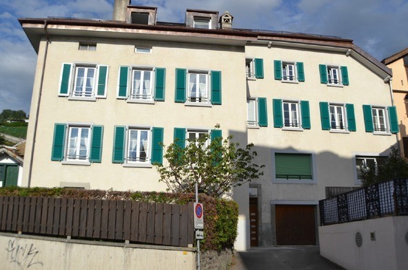 Mehrfamilienhaus mit grünen Fensterläden