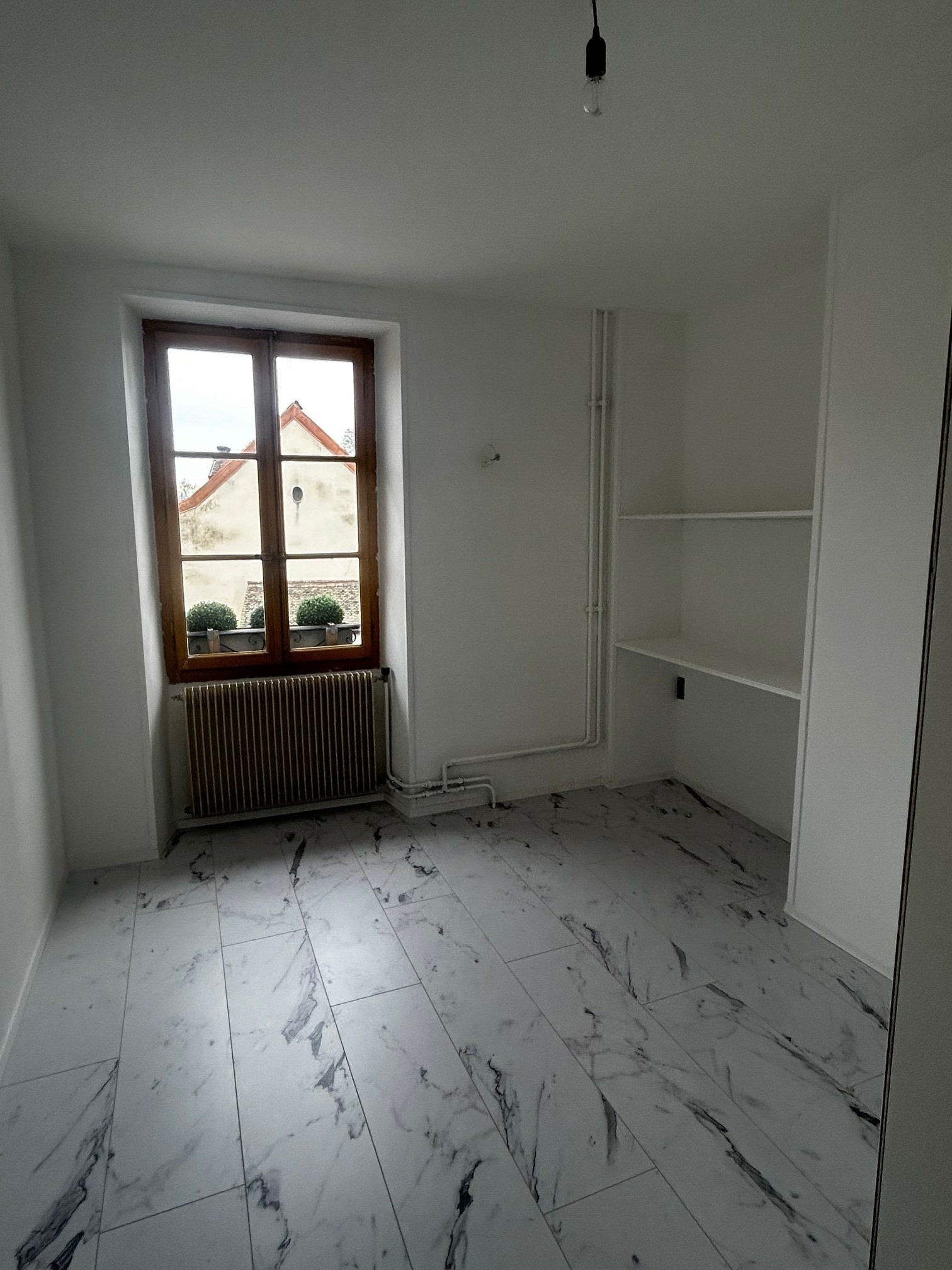 Leerer Raum mit Fliesenboden und Fenster