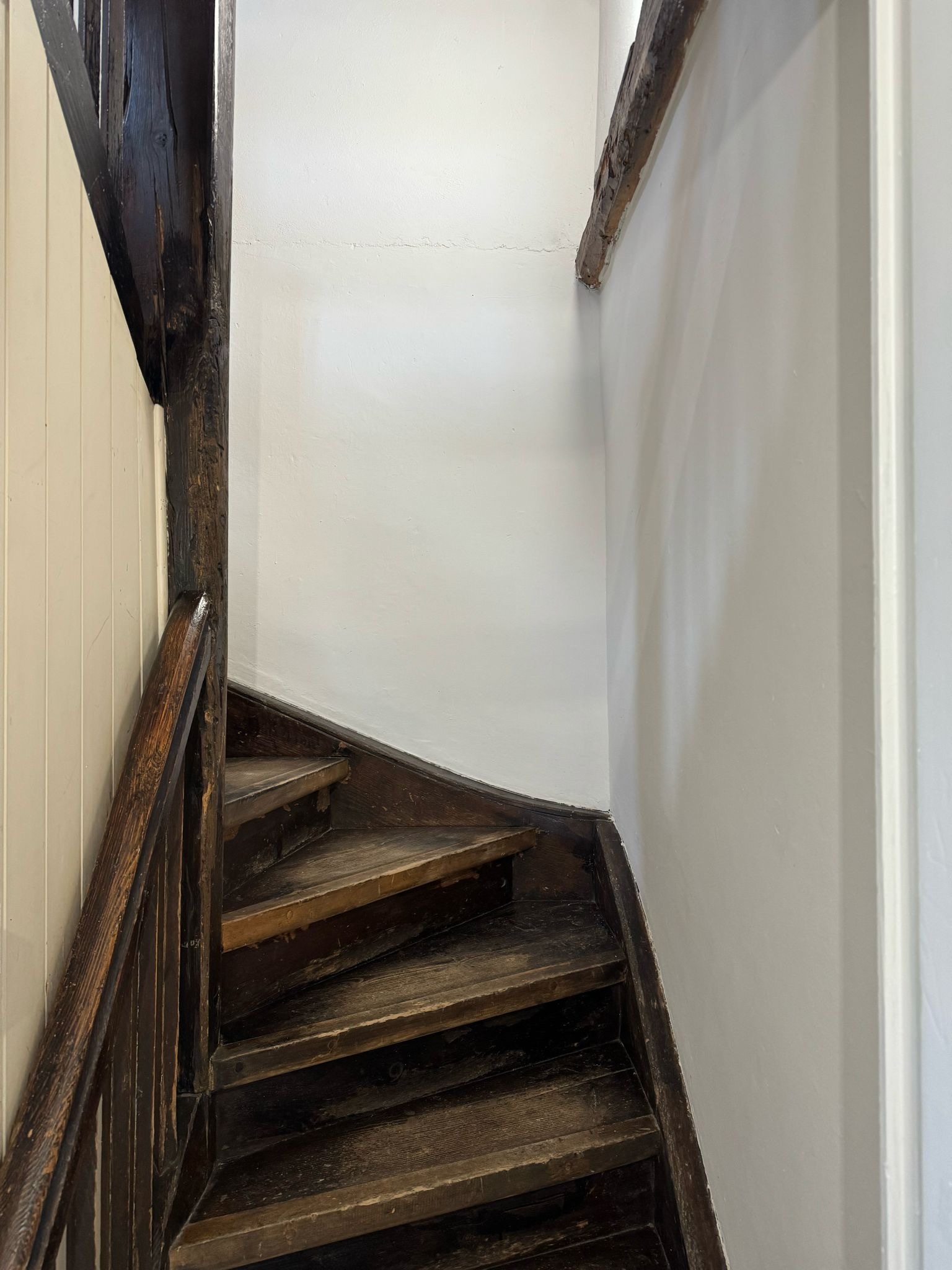 Enge Holztreppe mit sichtbaren Balken