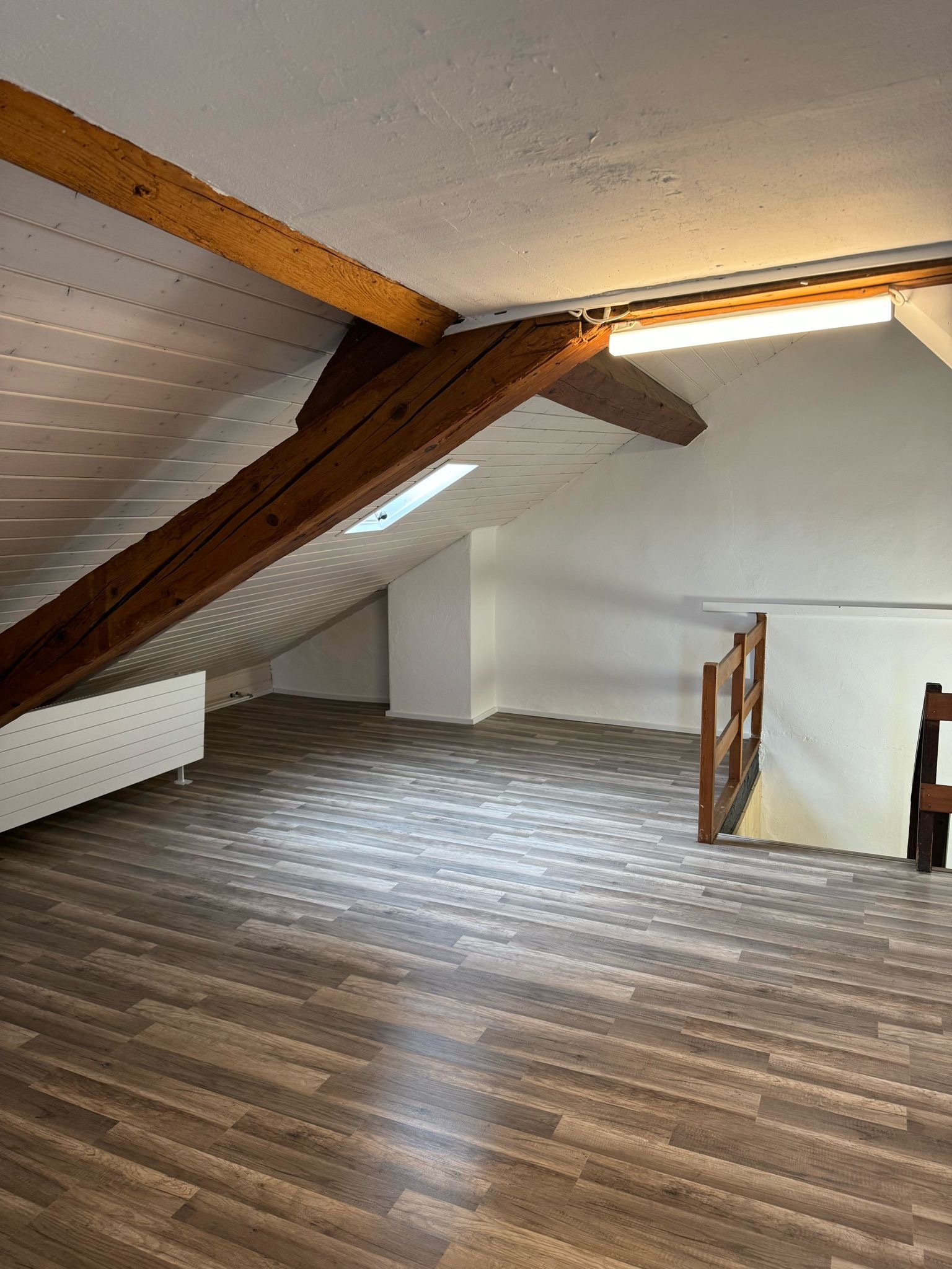 Ausgebauter Dachboden mit sichtbaren Holzbalken