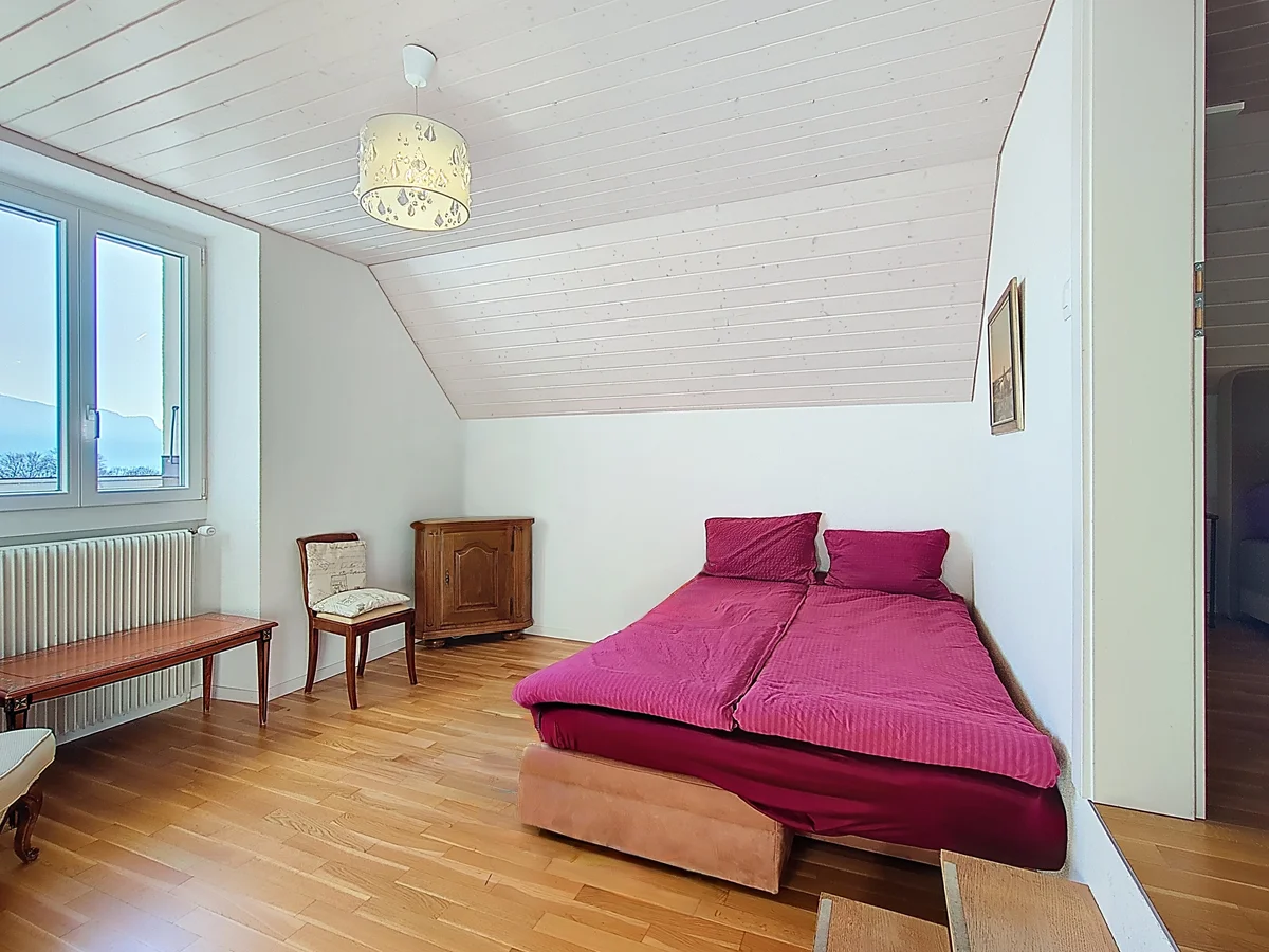 Helles Schlafzimmer mit Holzdecke und Doppelbett